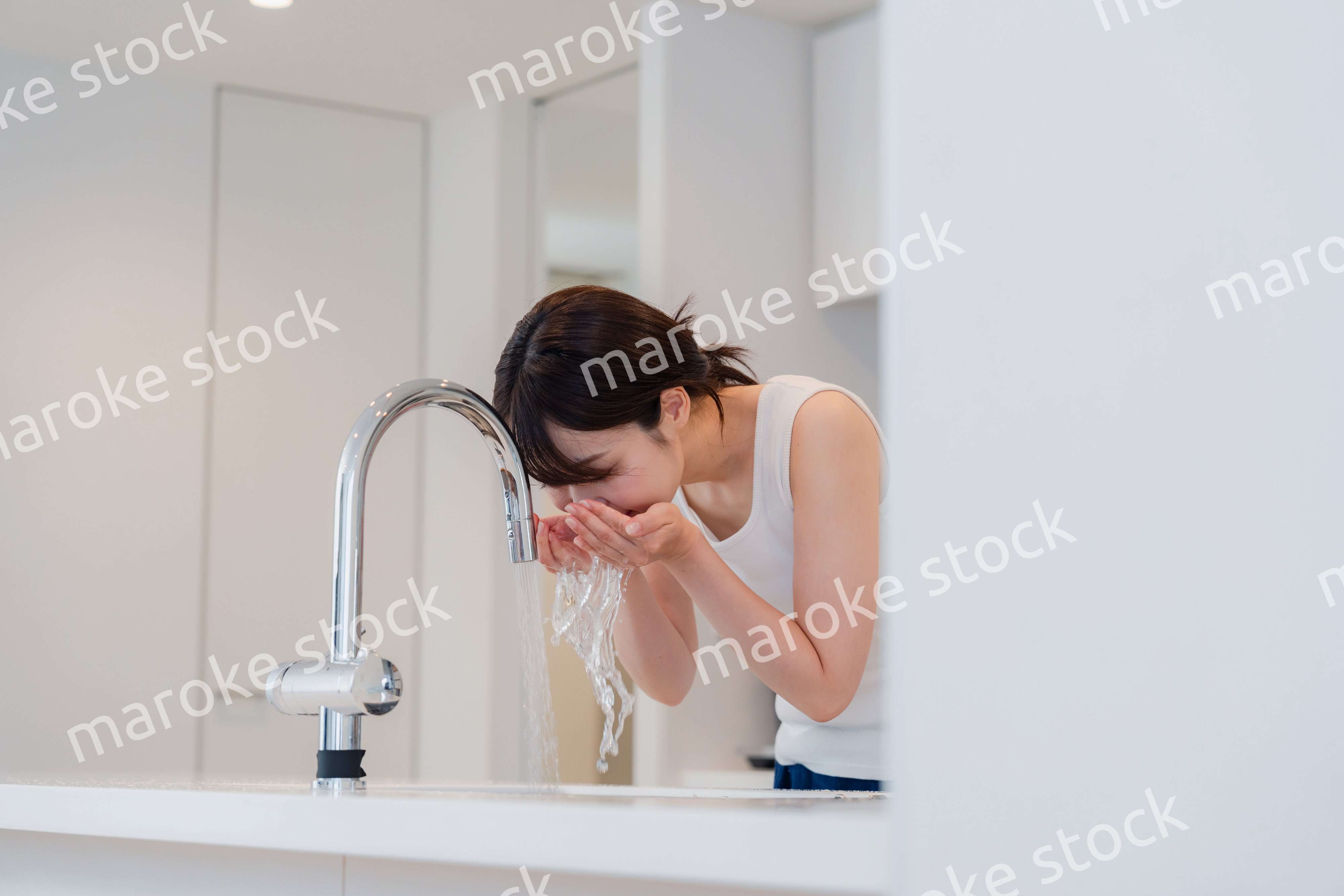 家で洗顔をする若い女性