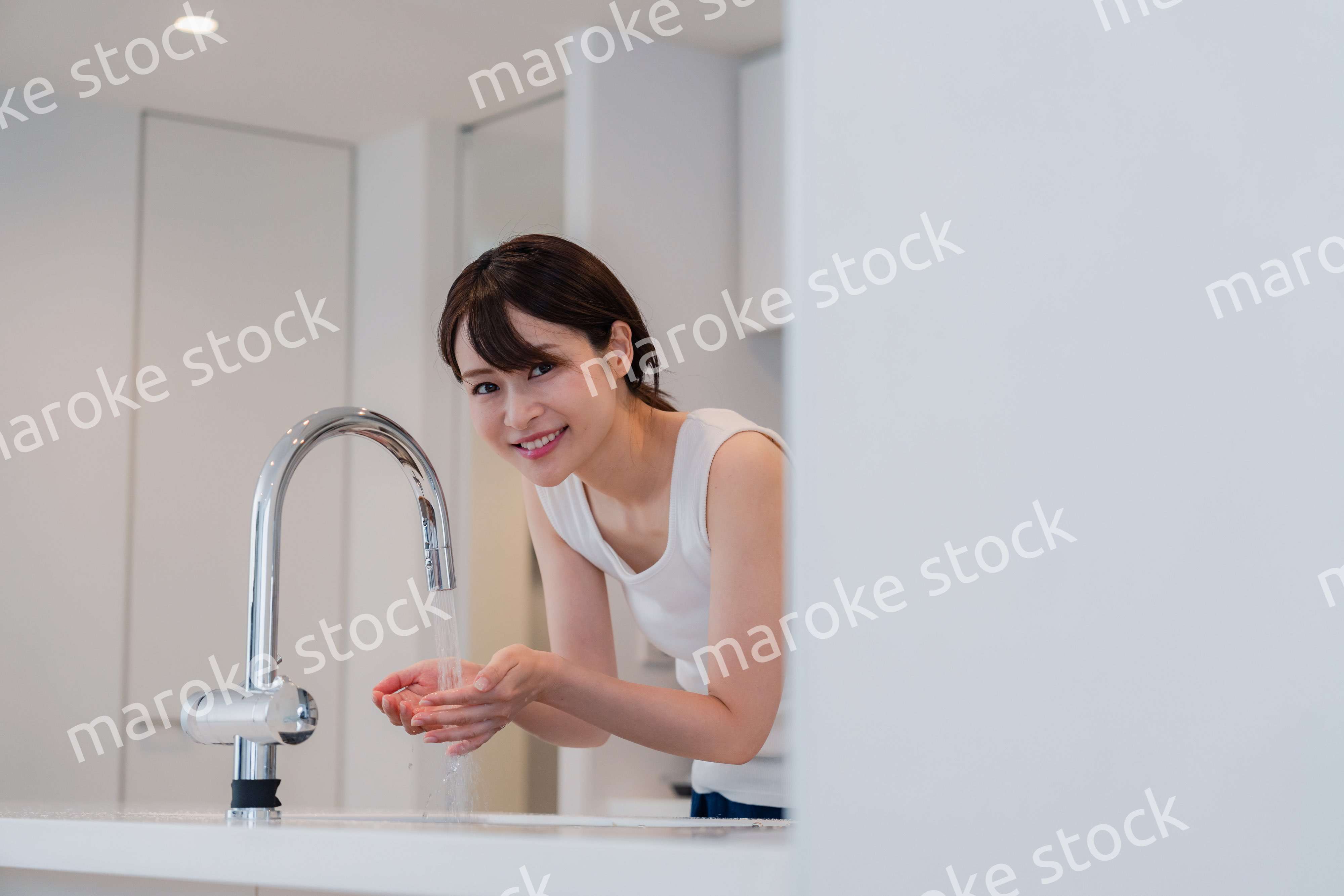 家で洗顔をする若い女性