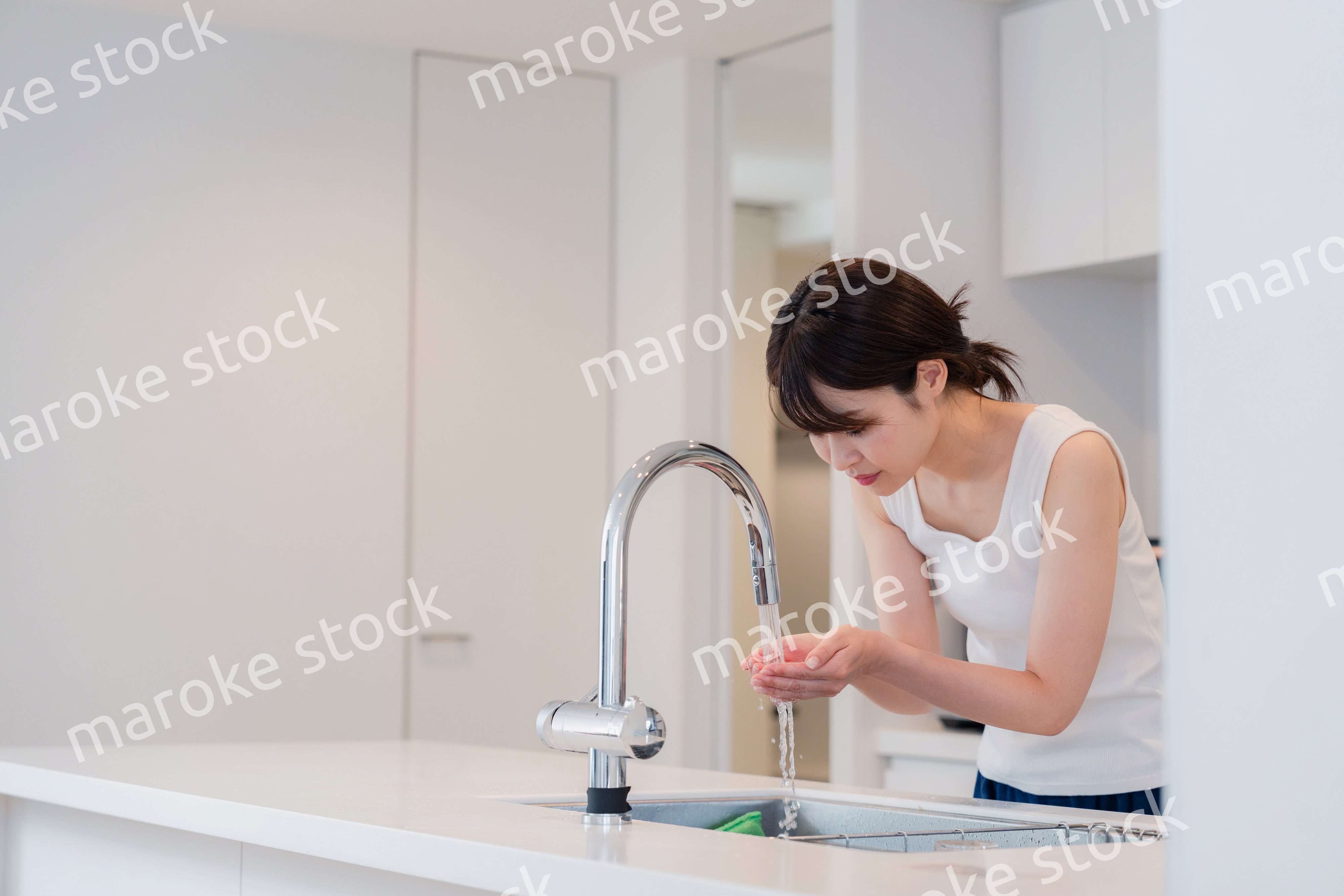 家で洗顔をする若い女性