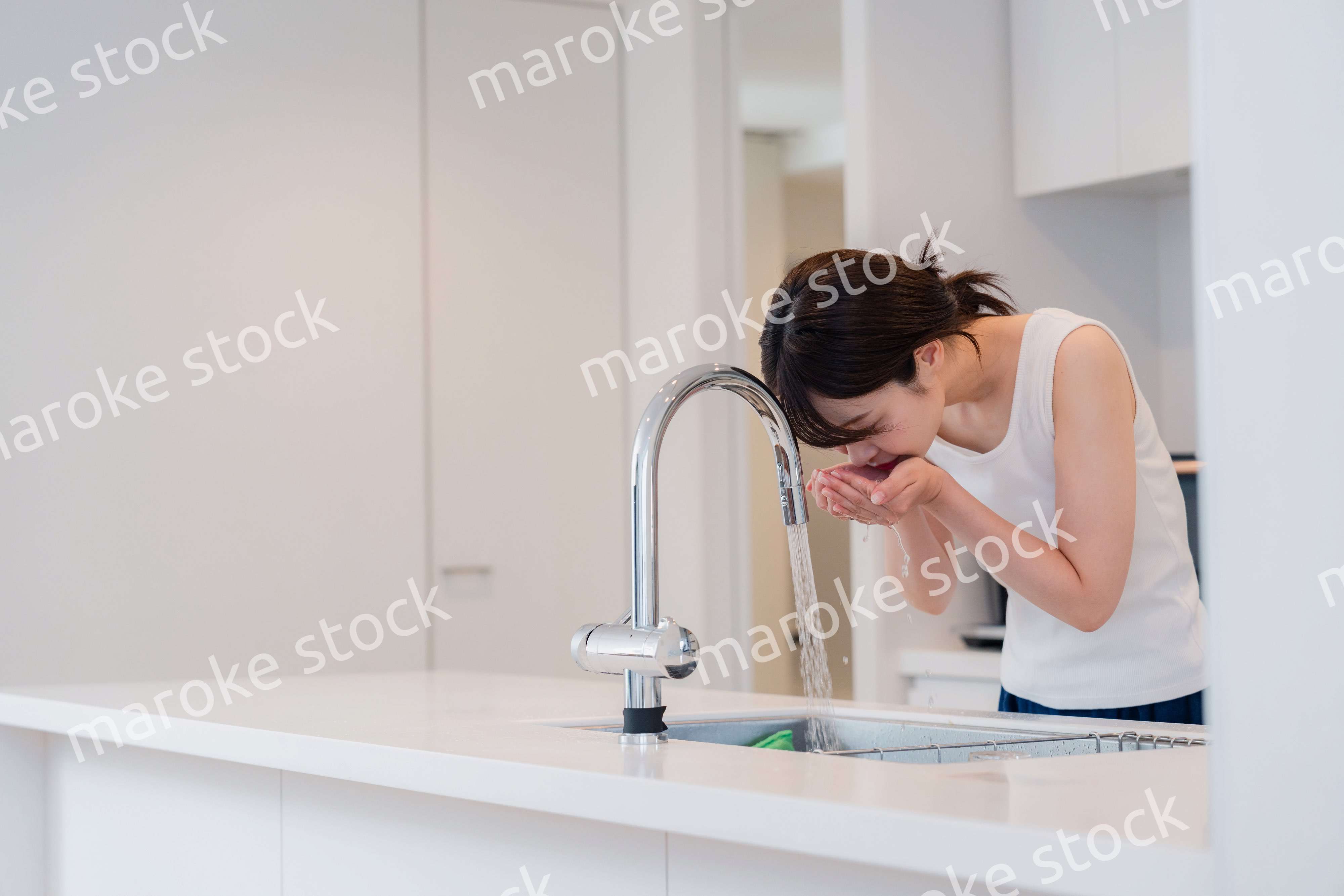 家で洗顔をする若い女性