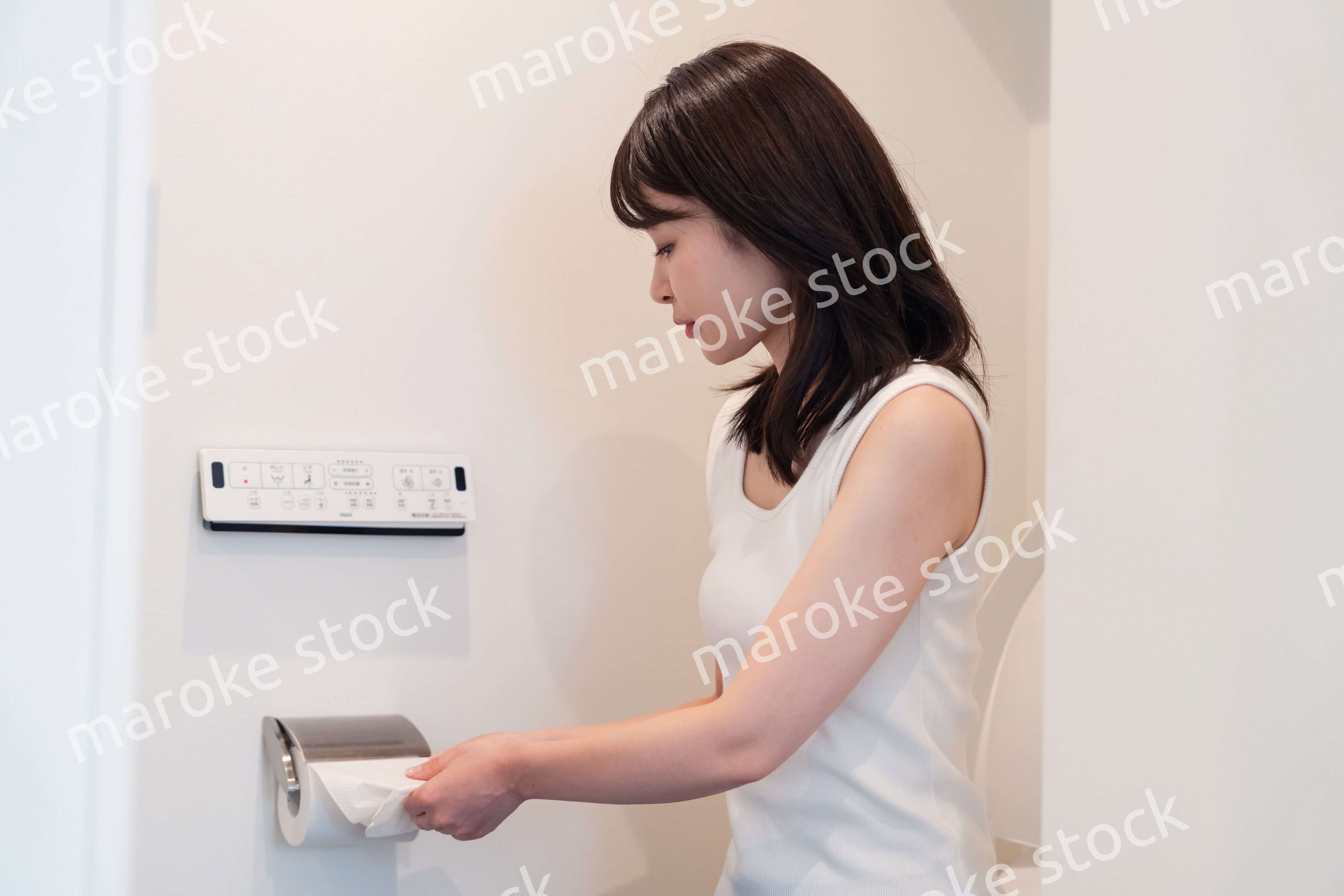 トイレットペーパーを引っ張る若い女性