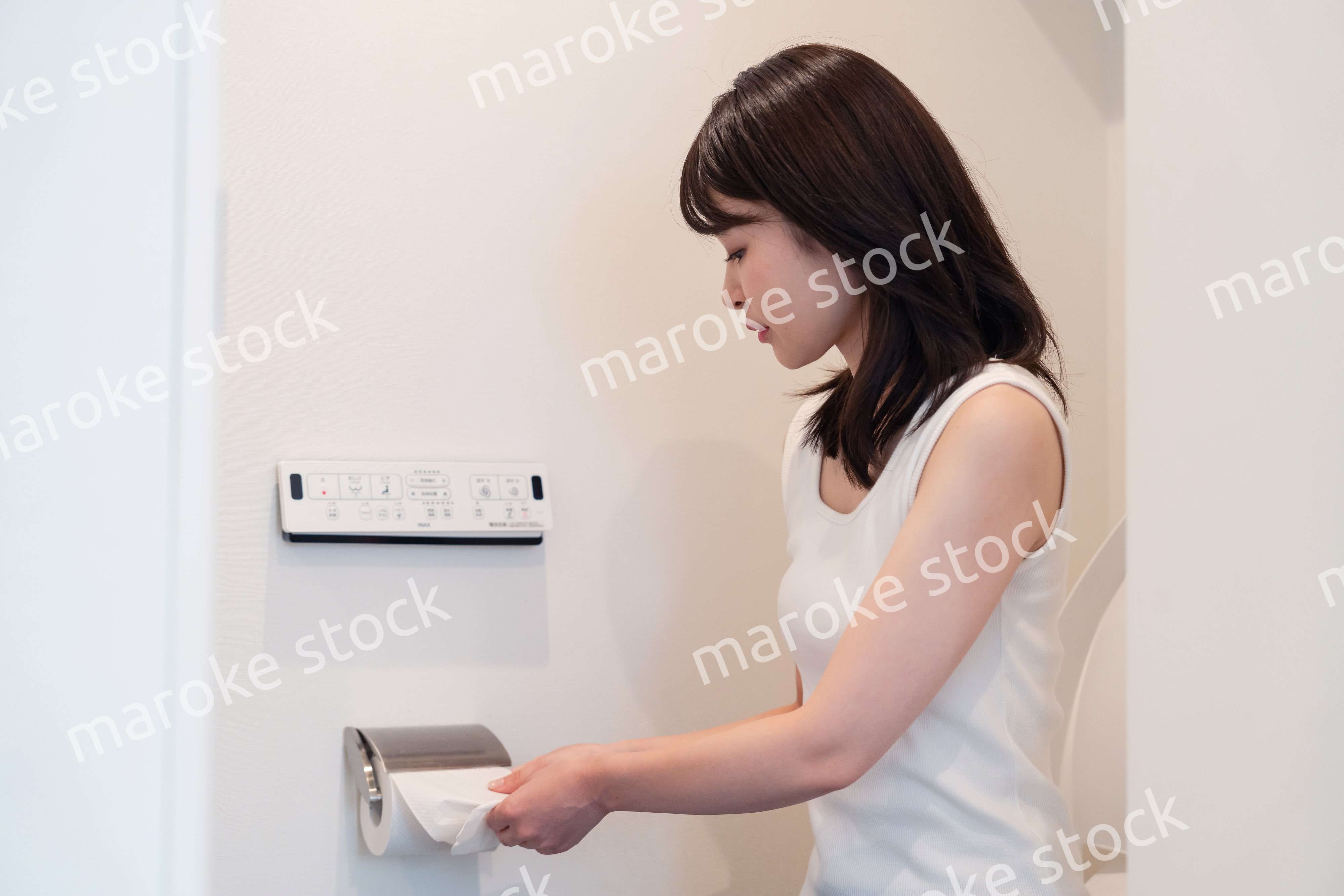 トイレットペーパーを引っ張る若い女性