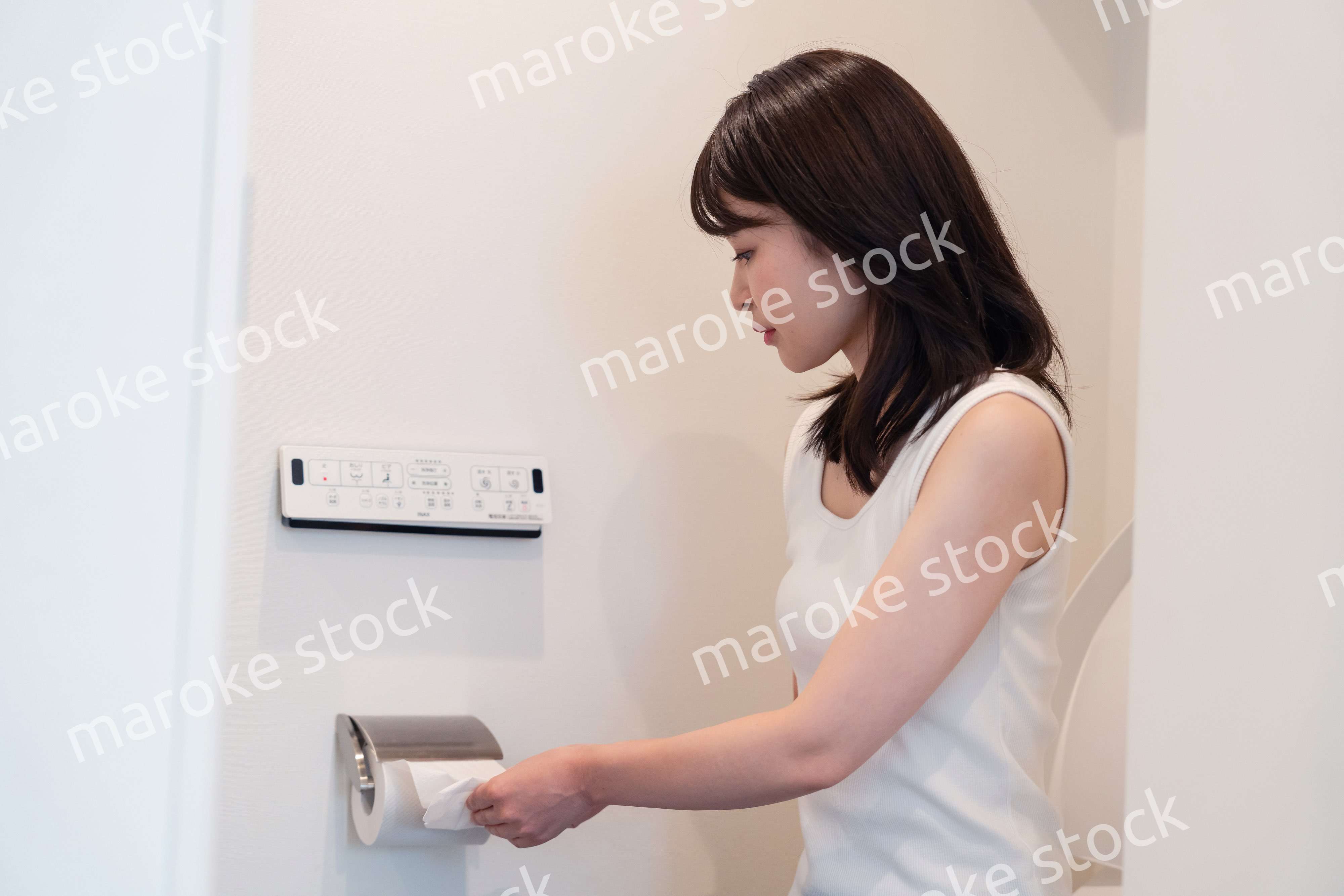 トイレットペーパーを引っ張る若い女性