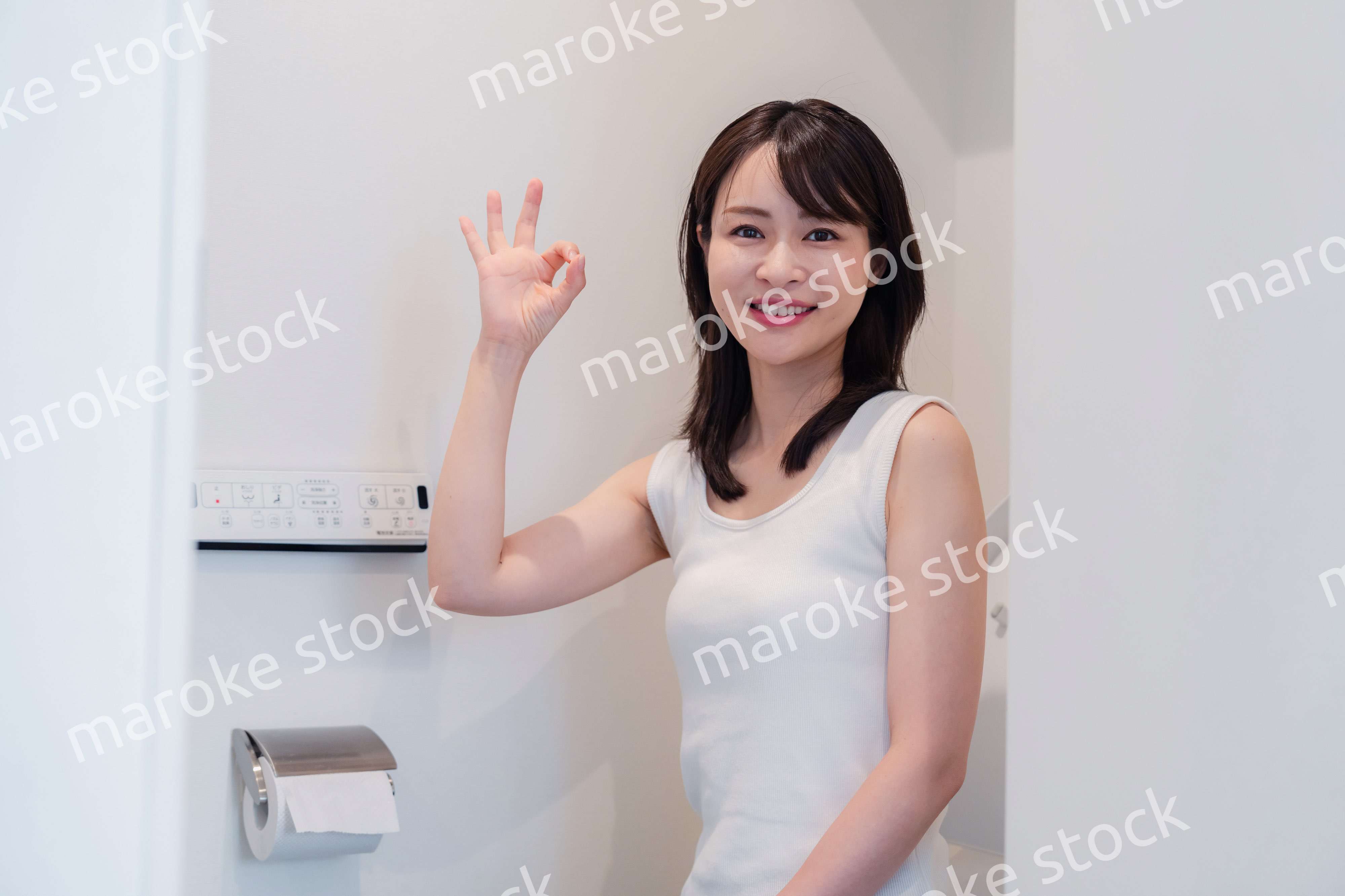 トイレでOKサインをする若い女性