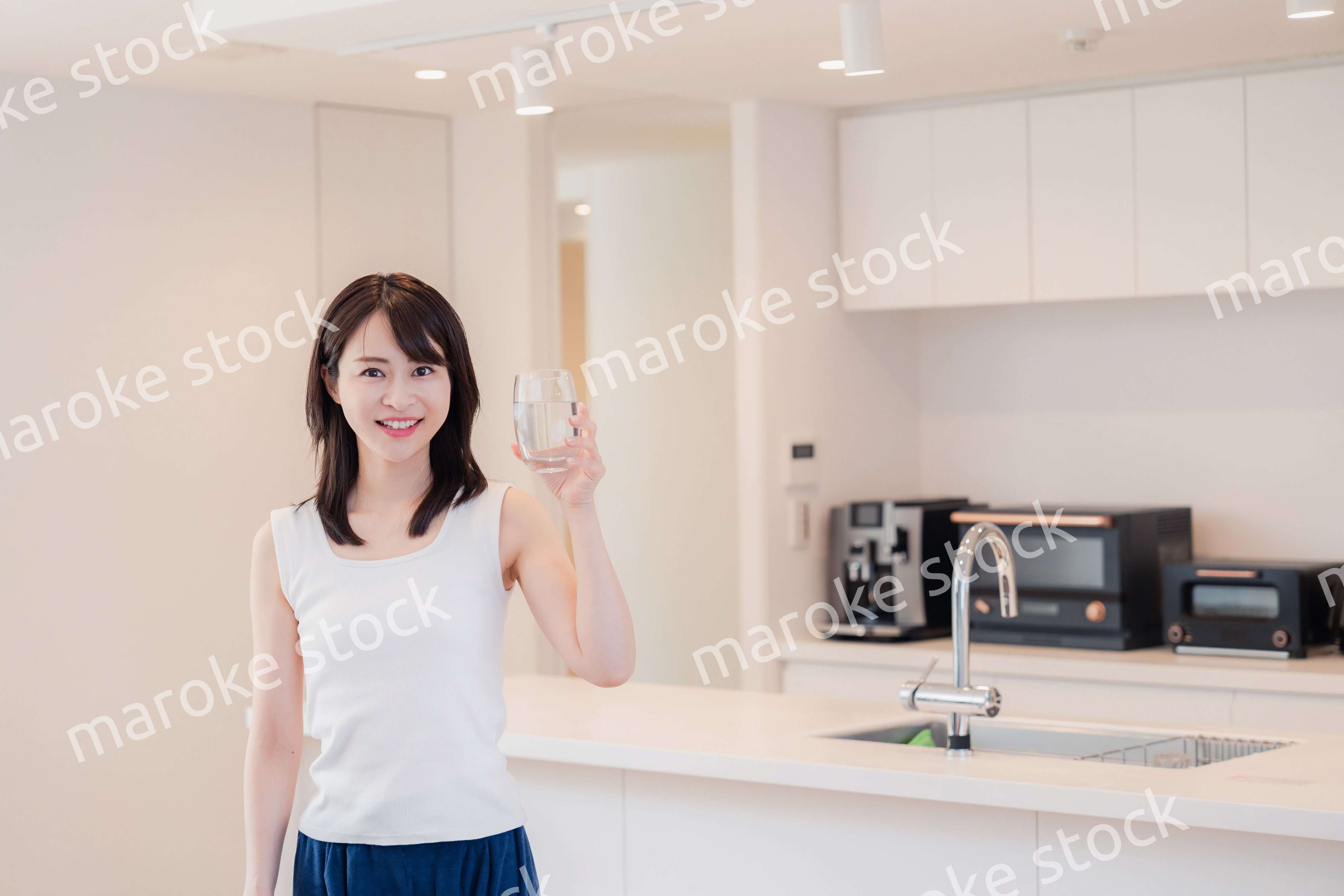 家で水を飲む若い女性