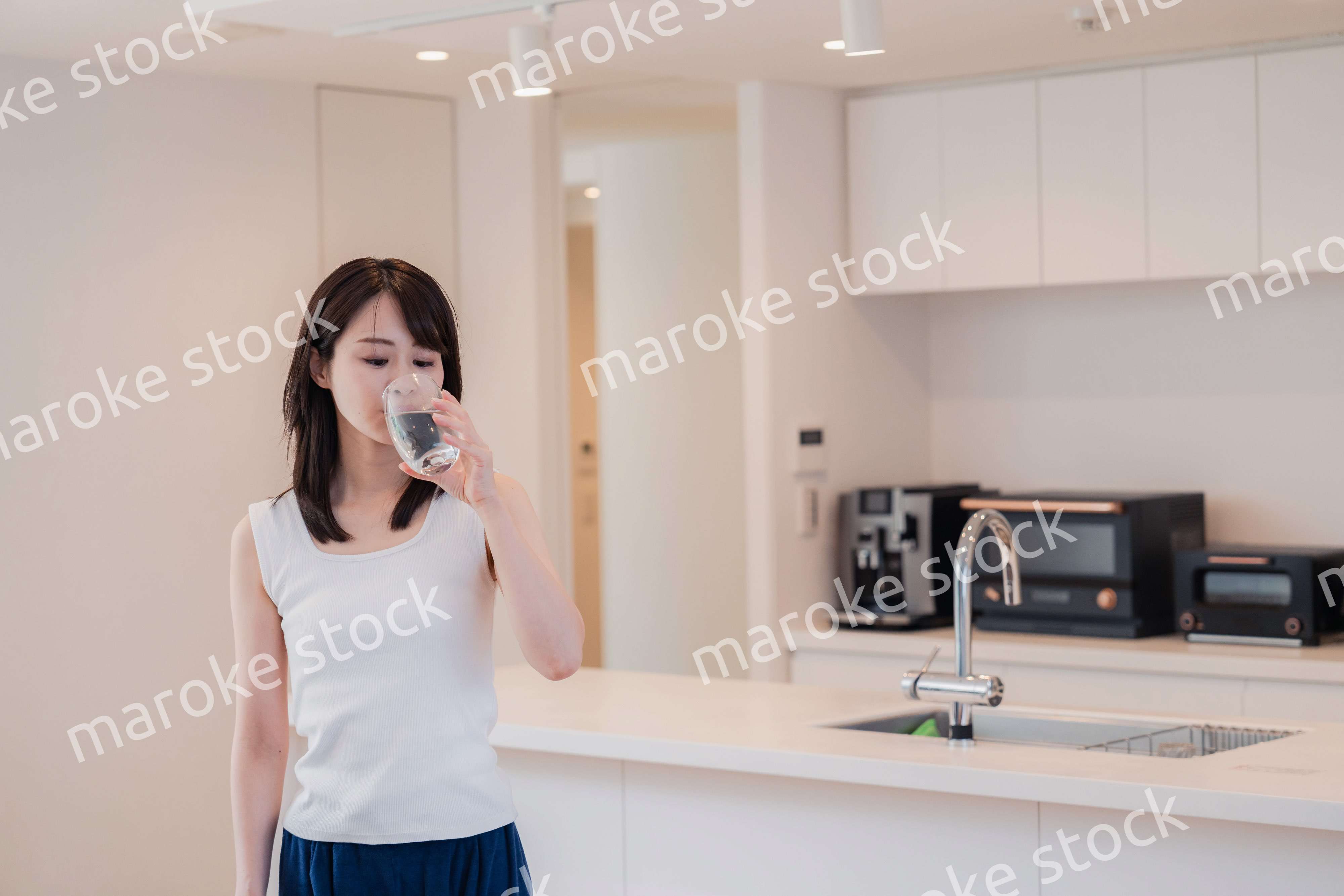 家で水を飲む若い女性