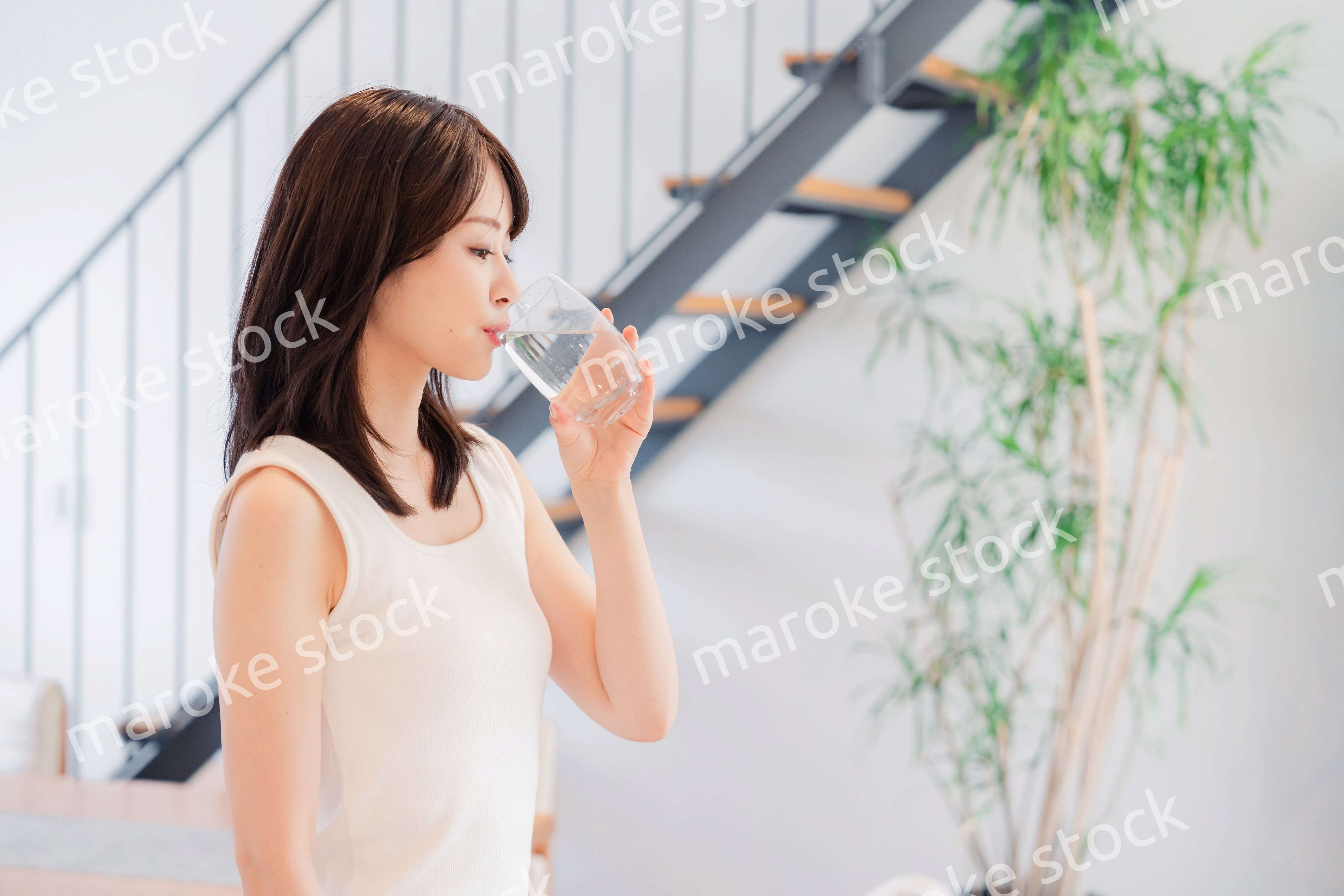 家で水を飲む若い女性