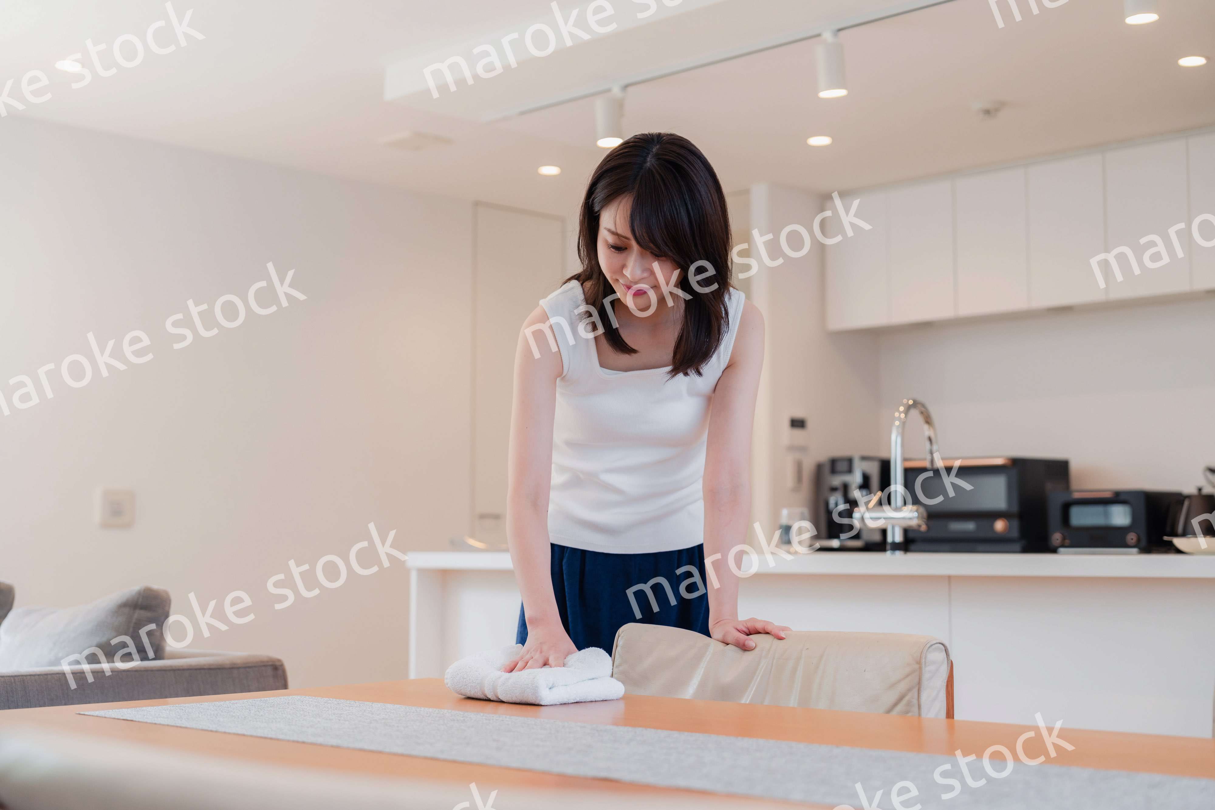 ダイニングテーブルを拭く若い女性
