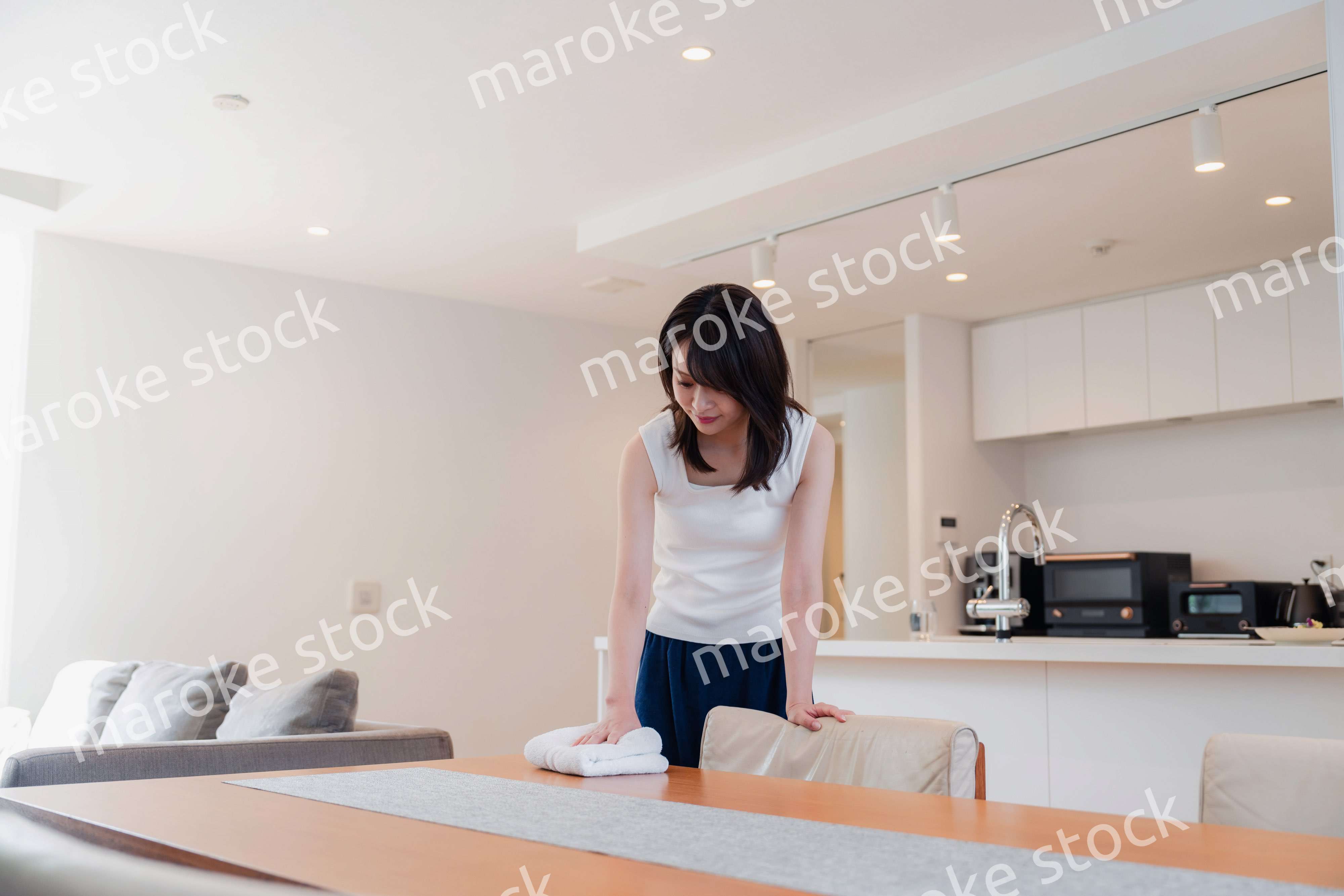 ダイニングテーブルを拭く若い女性