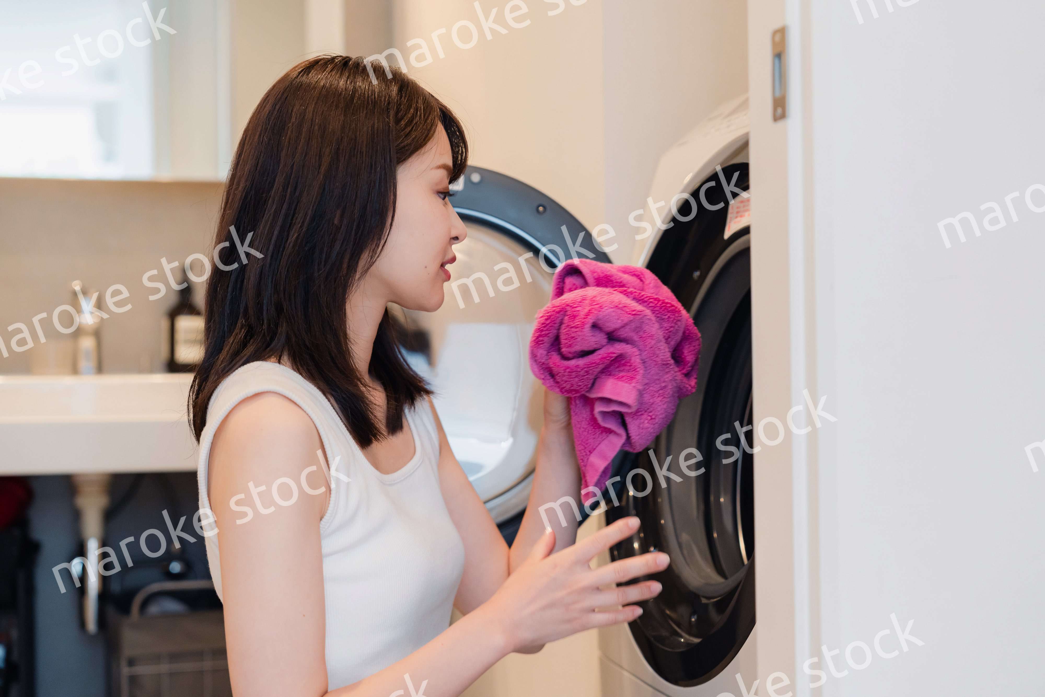 ドラム式洗濯機を使う若い女性