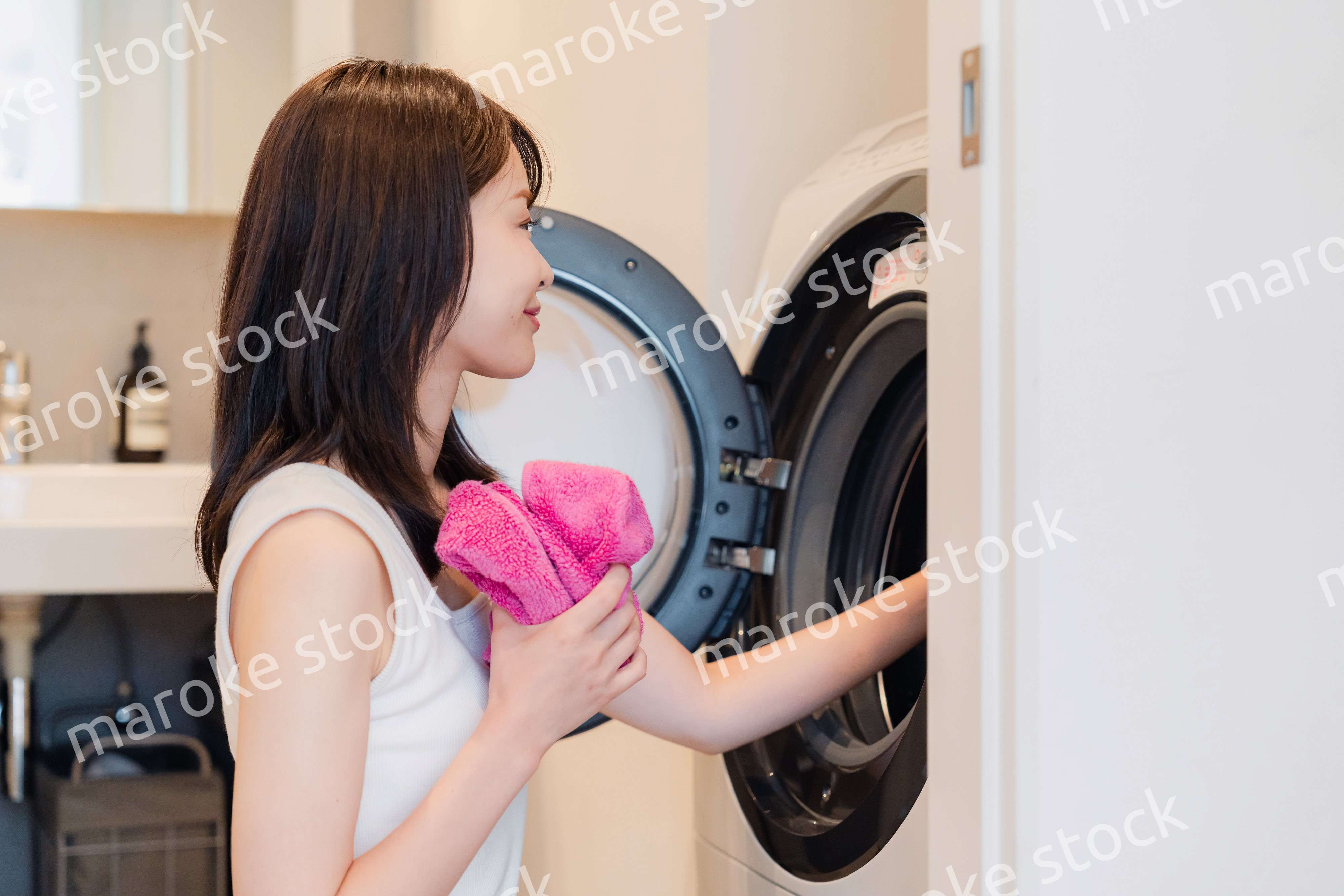 ドラム式洗濯機を使う若い女性