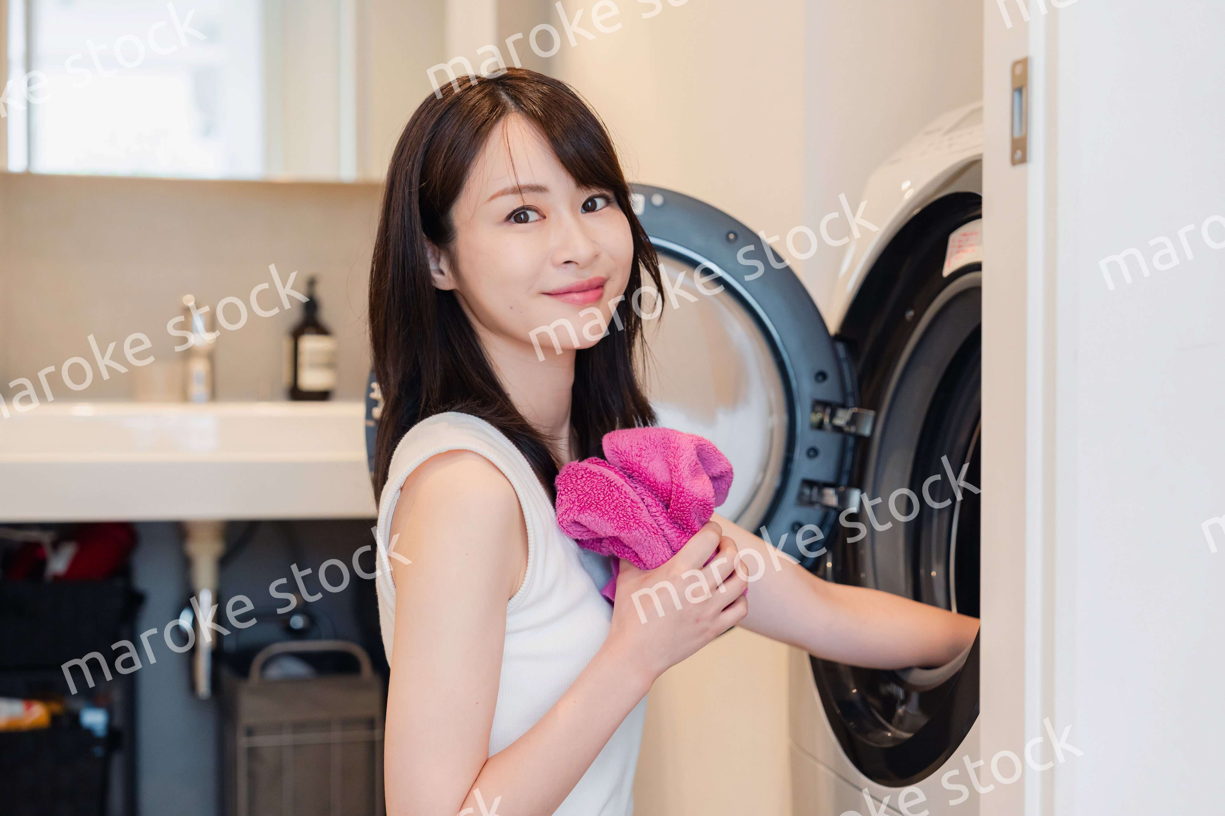 ドラム式洗濯機を使う若い女性