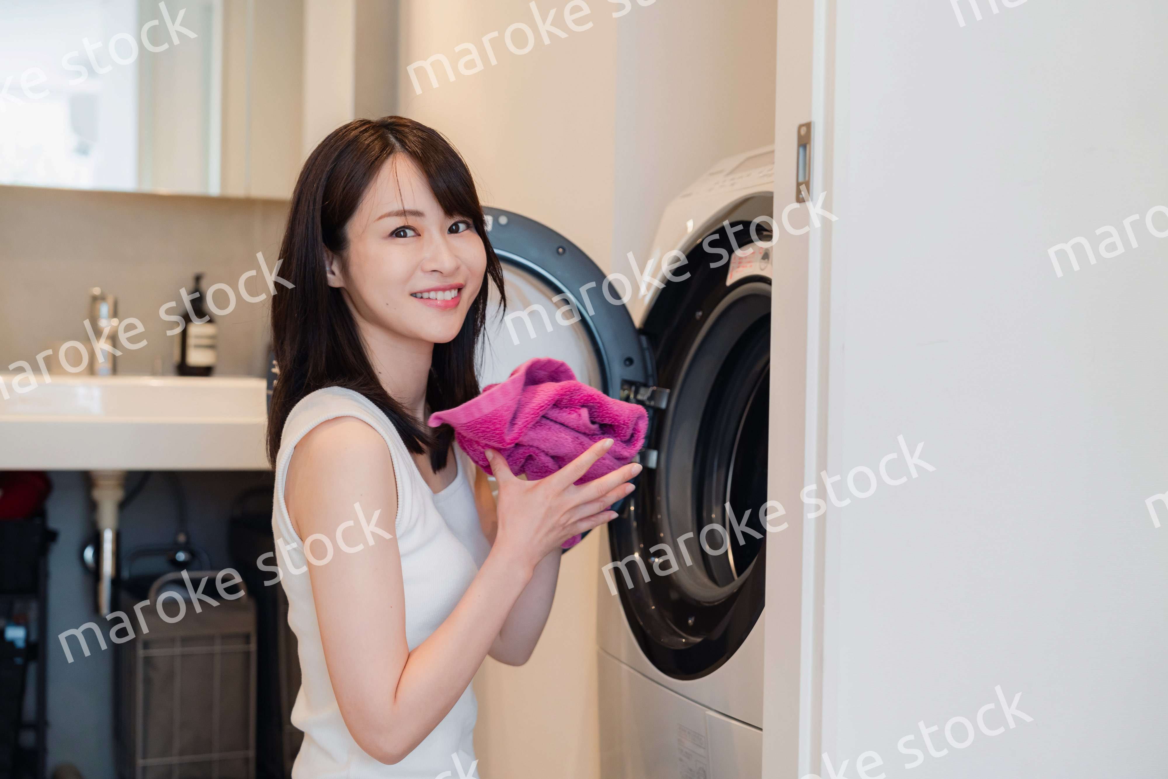 ドラム式洗濯機を使う若い女性