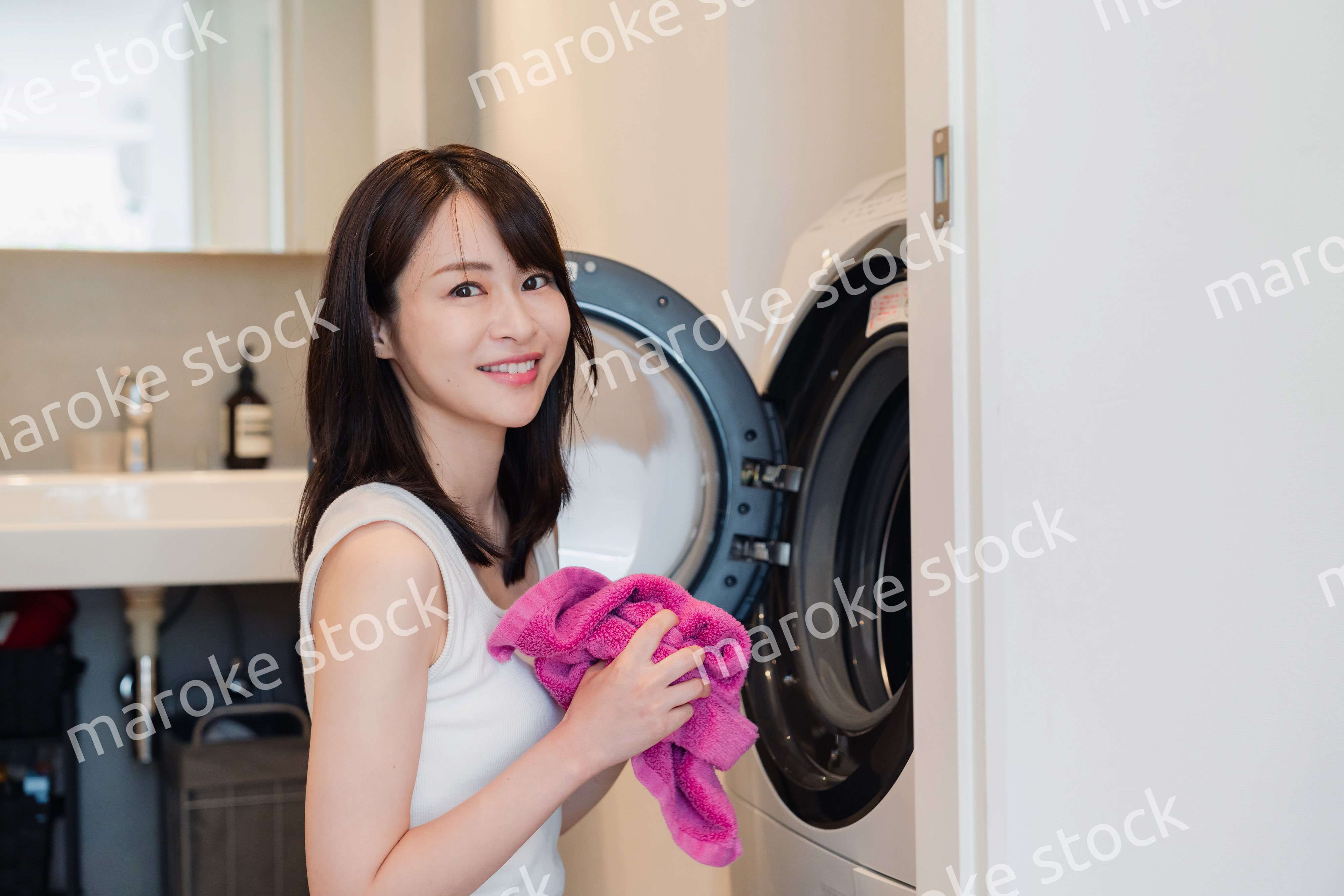 ドラム式洗濯機を使う若い女性