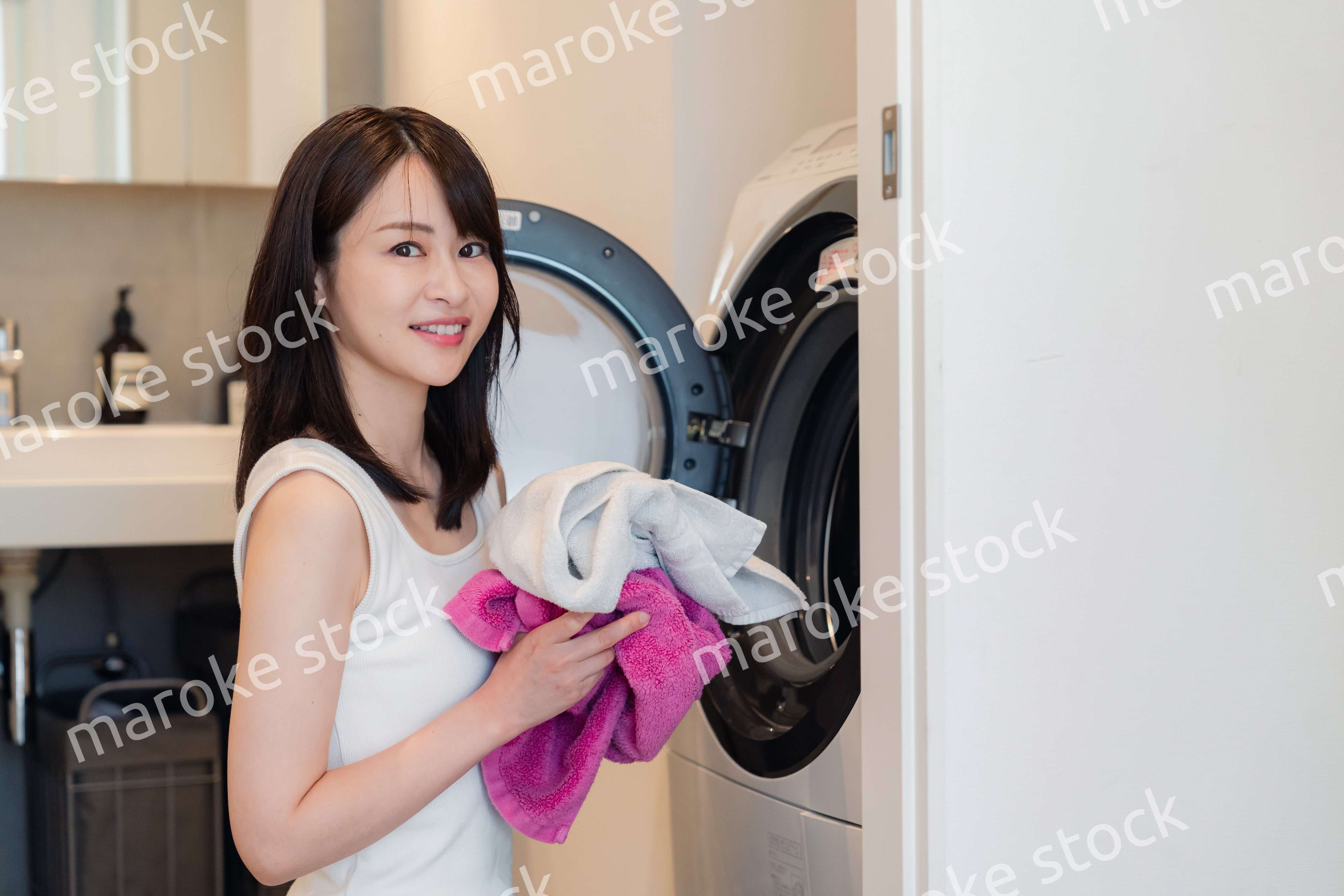 ドラム式洗濯機を使う若い女性