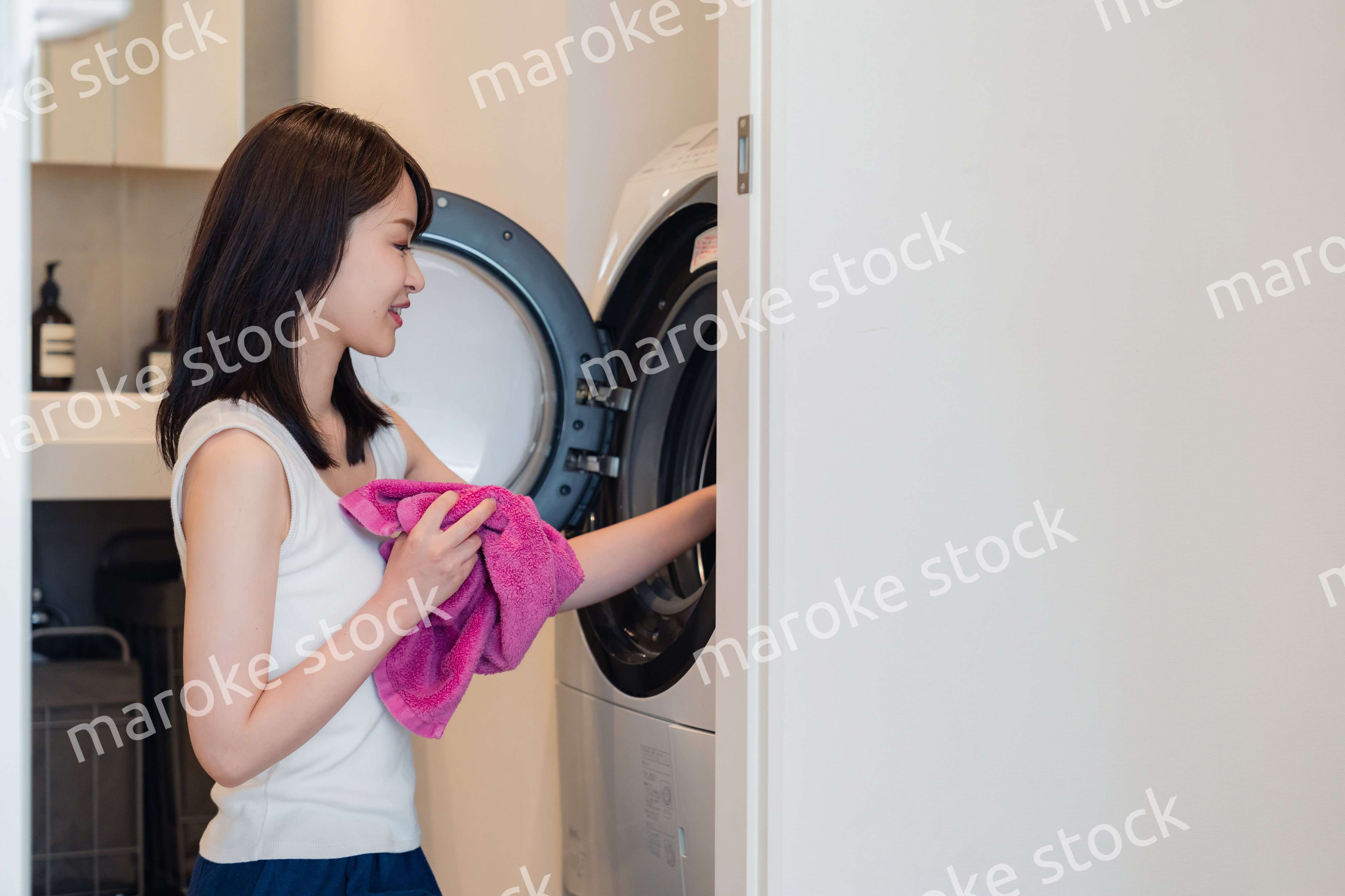 ドラム式洗濯機を使う若い女性