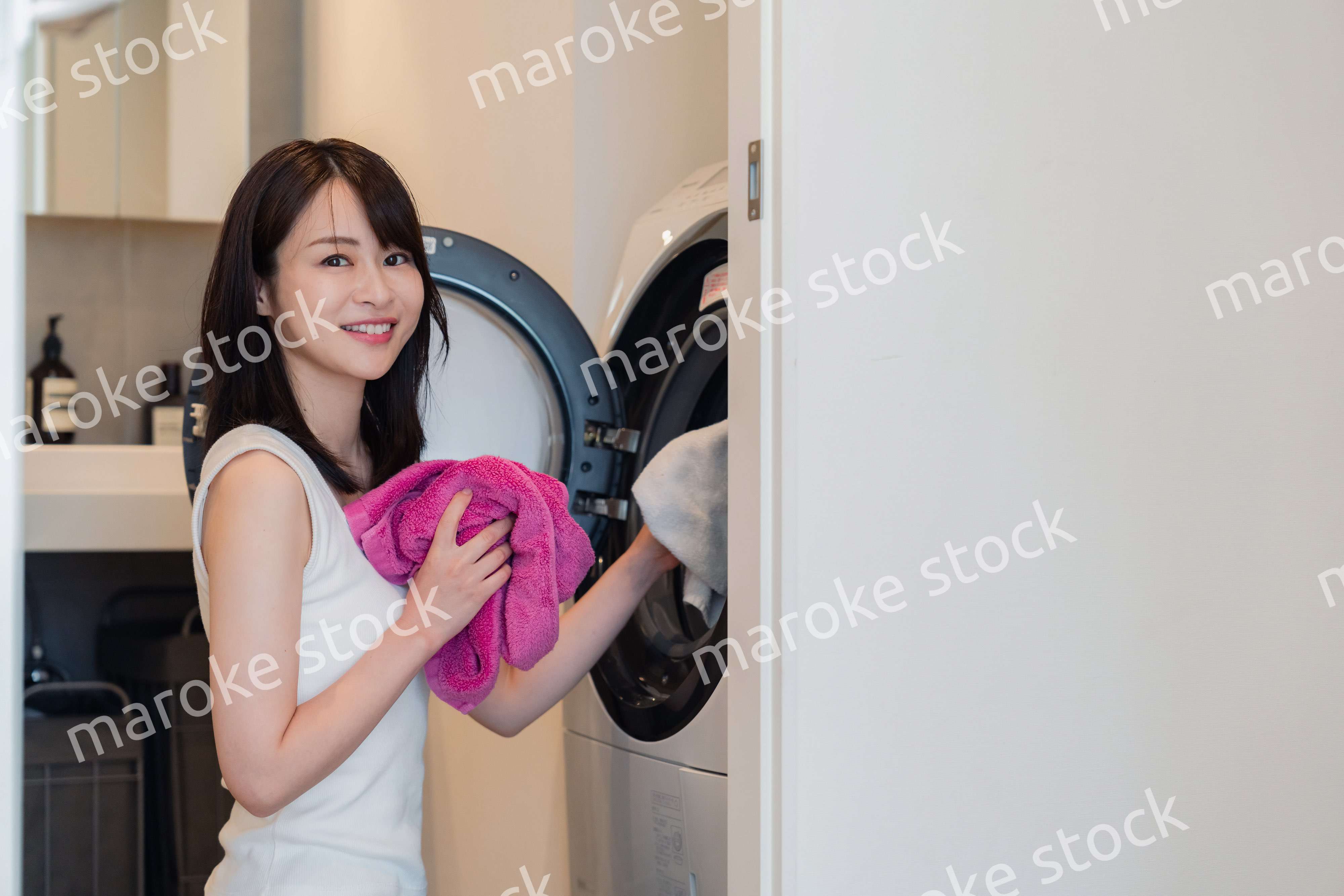 ドラム式洗濯機を使う若い女性