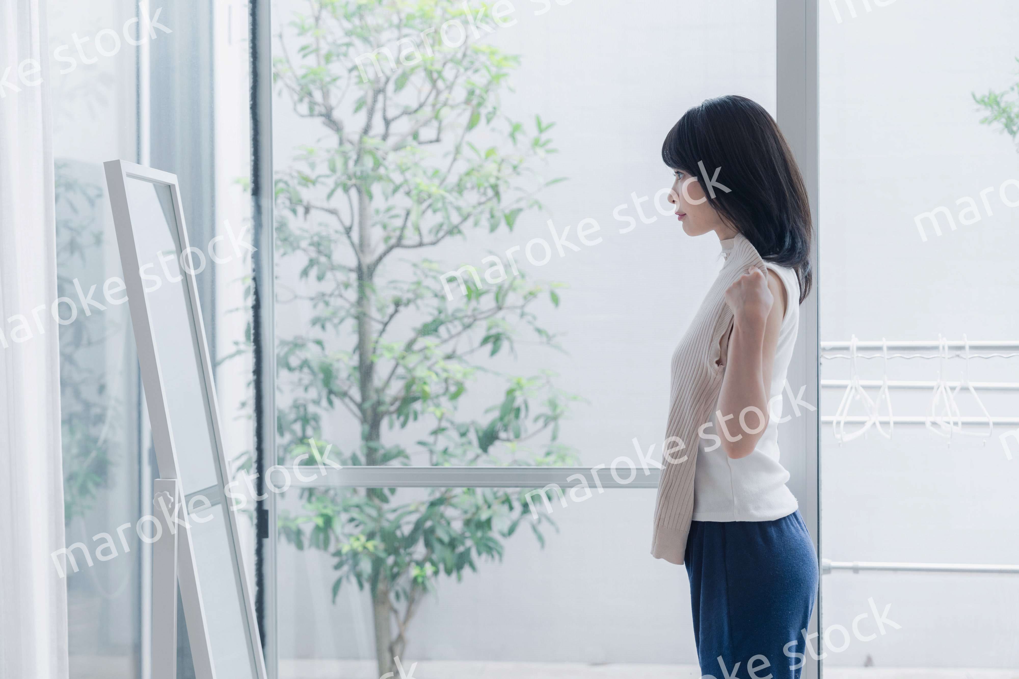 家でファッションの組み合わせを考える若い女性