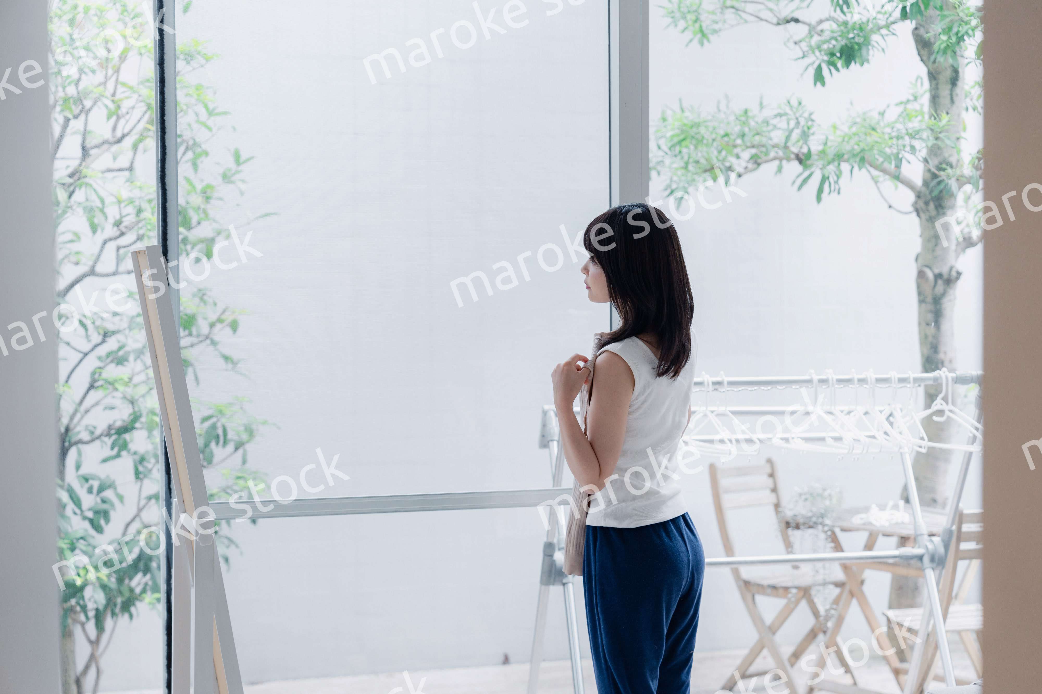 家でファッションの組み合わせを考える若い女性