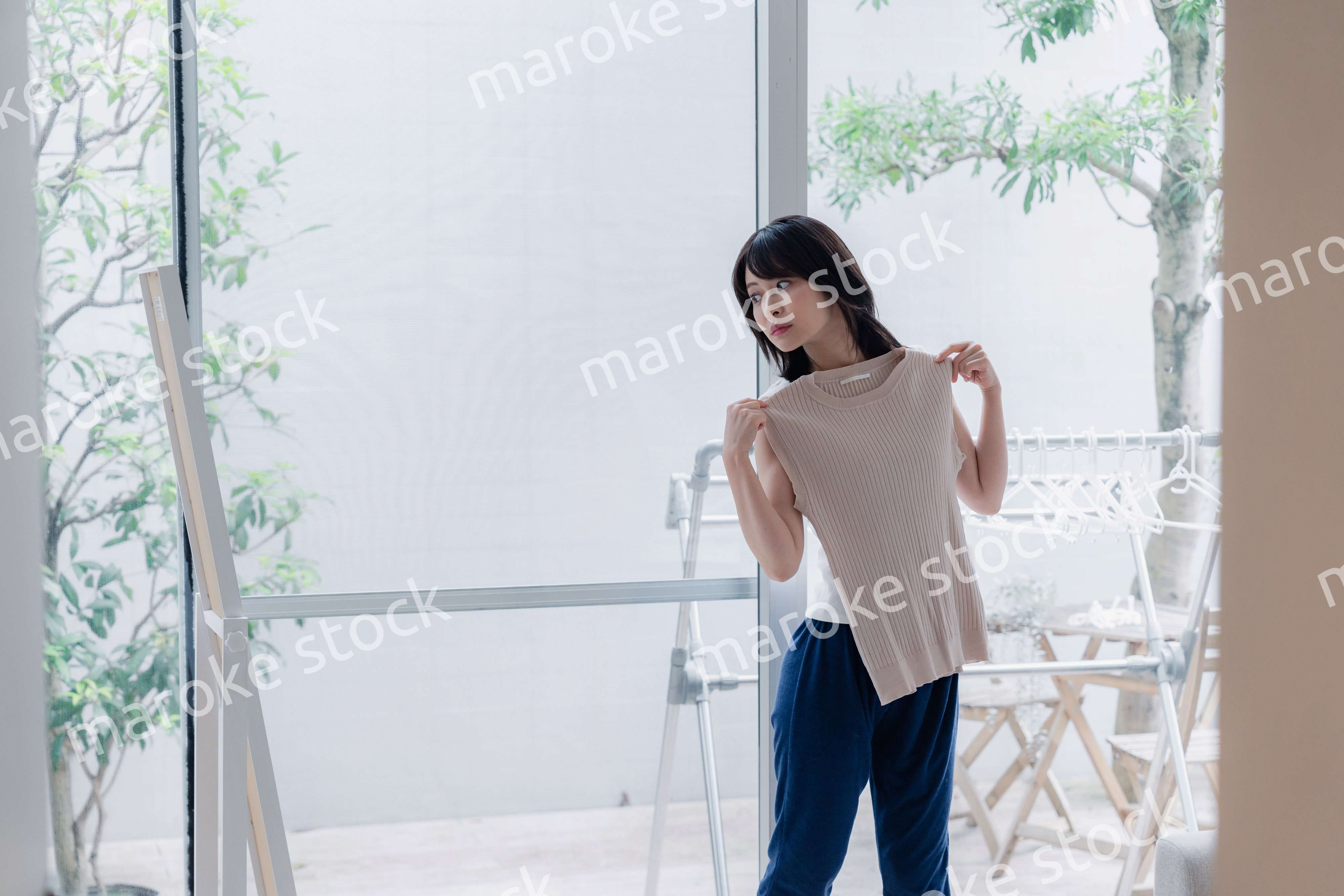 家でファッションの組み合わせを考える若い女性