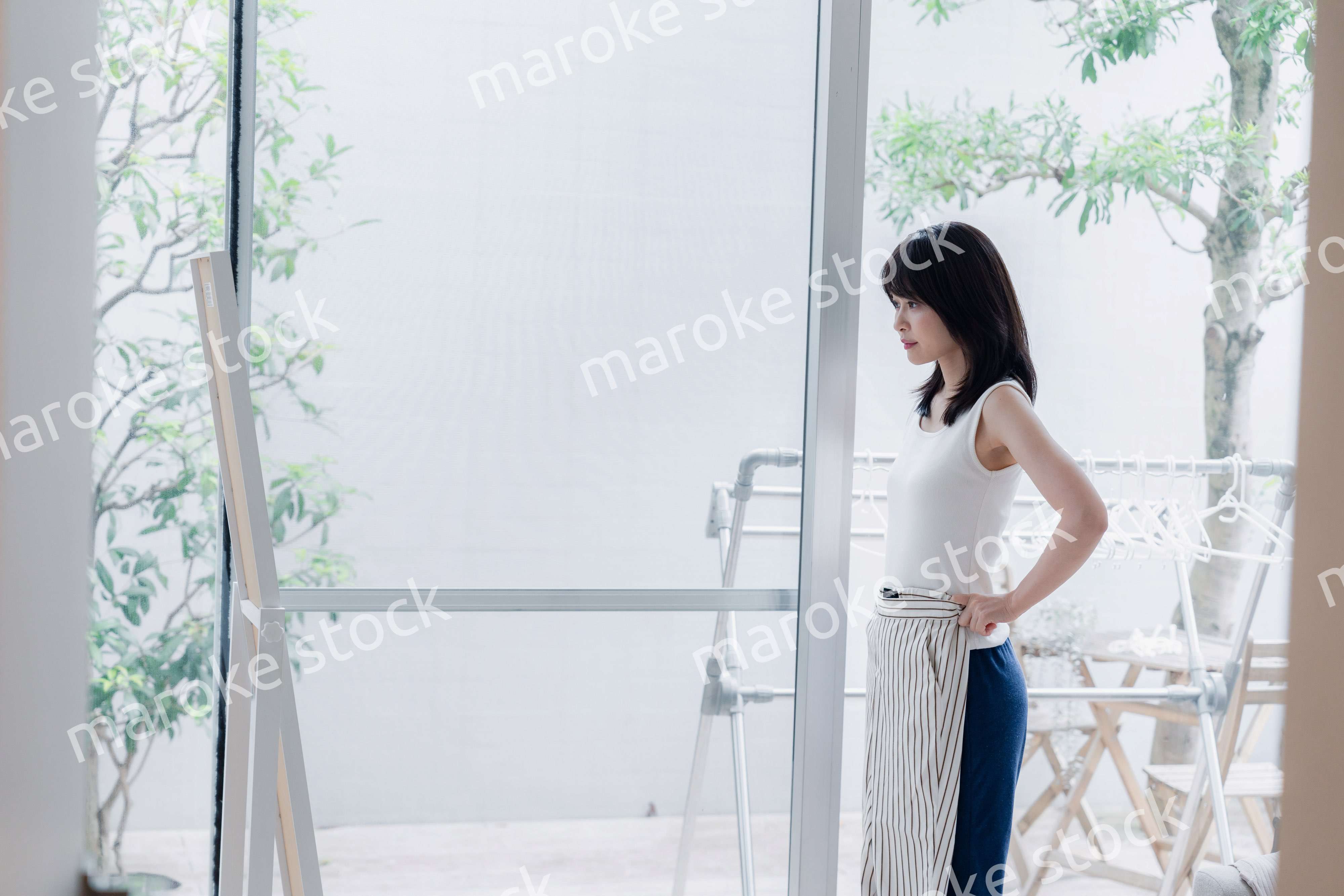 家でファッションの組み合わせを考える若い女性