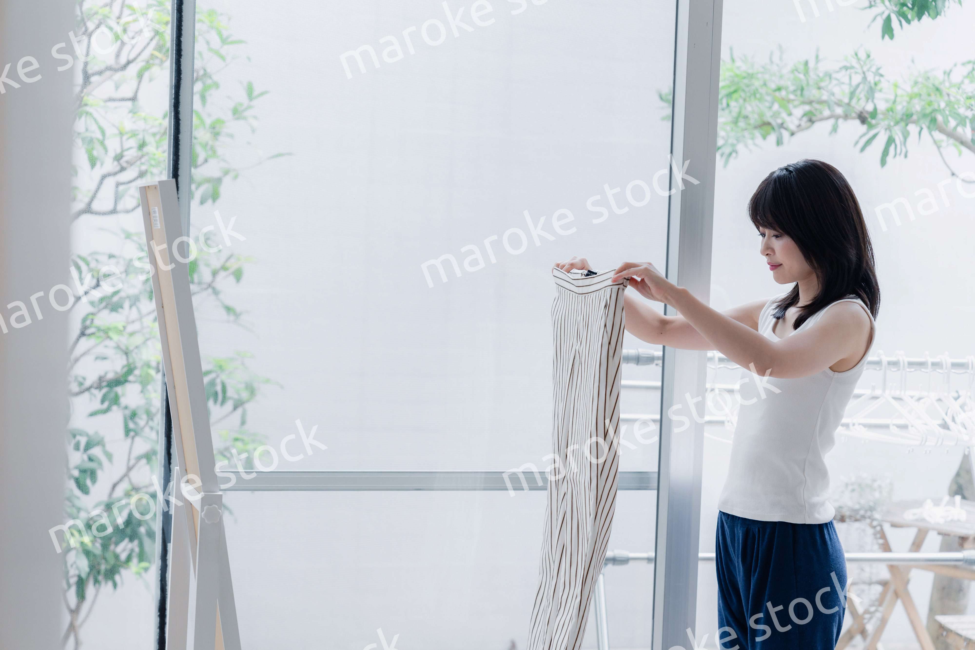 家でファッションの組み合わせを考える若い女性