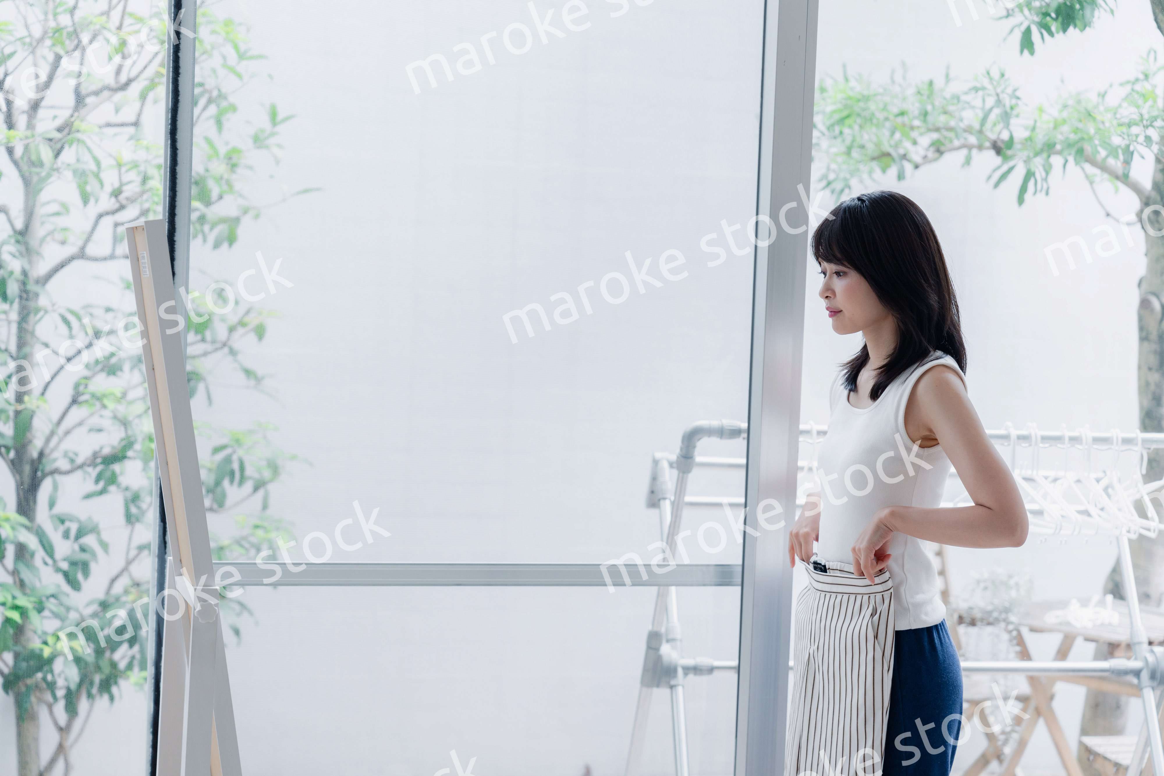 家でファッションの組み合わせを考える若い女性