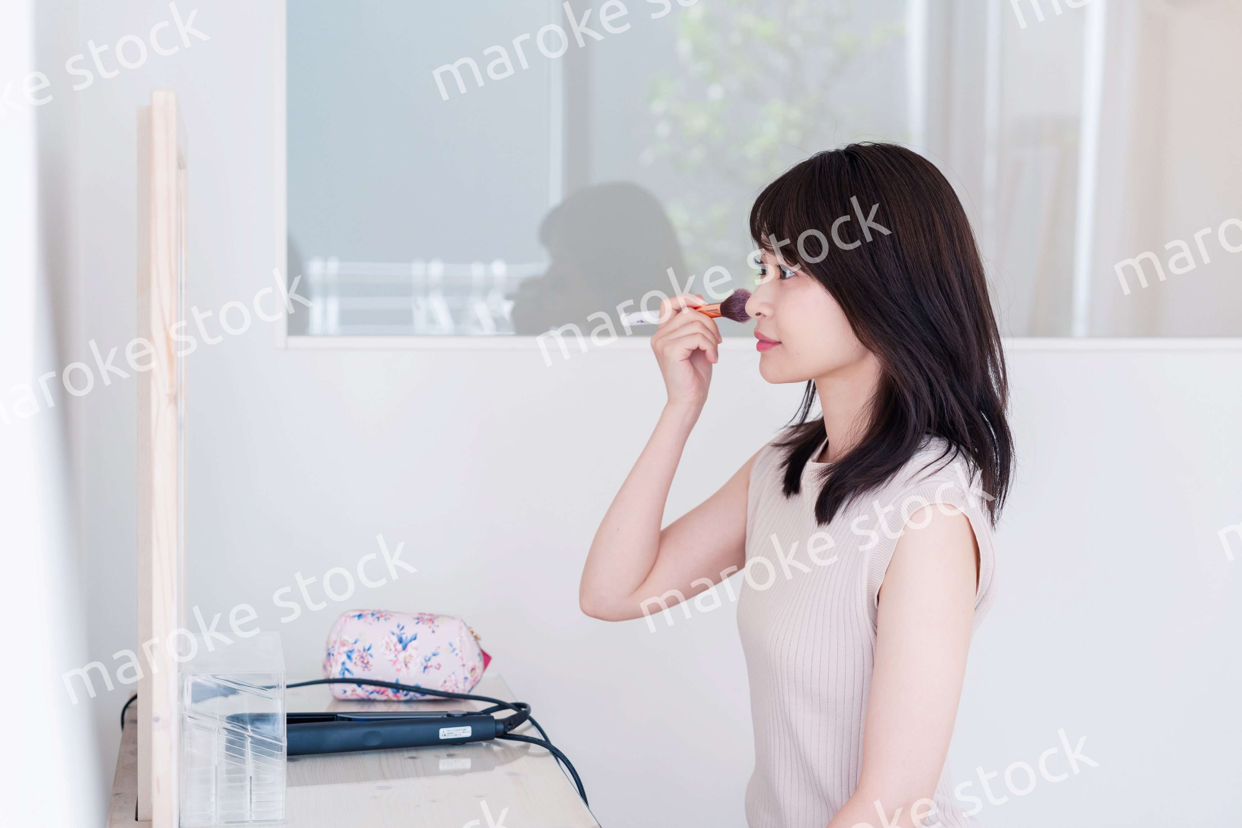 家でメイクをする若い女性