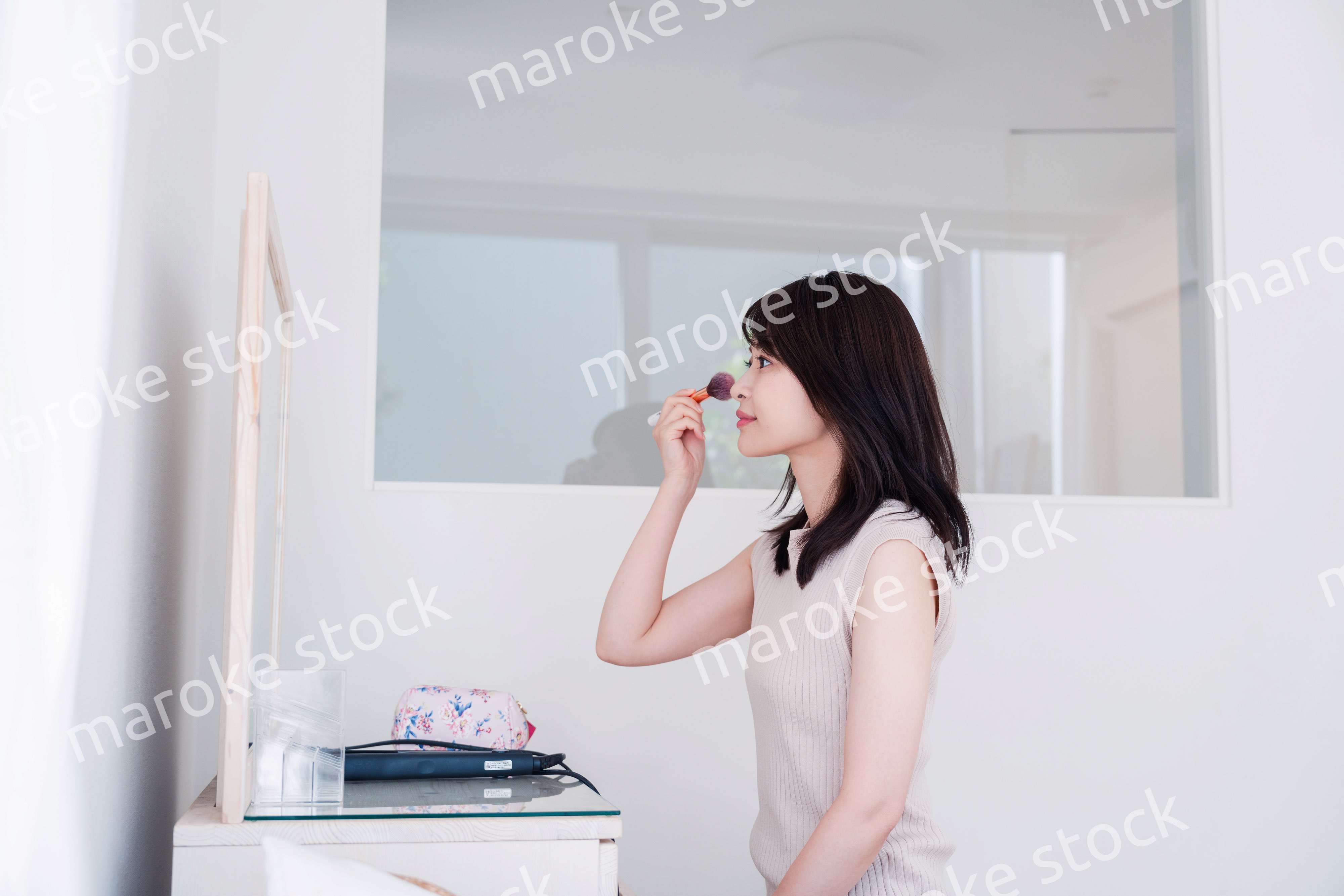 家でメイクをする若い女性