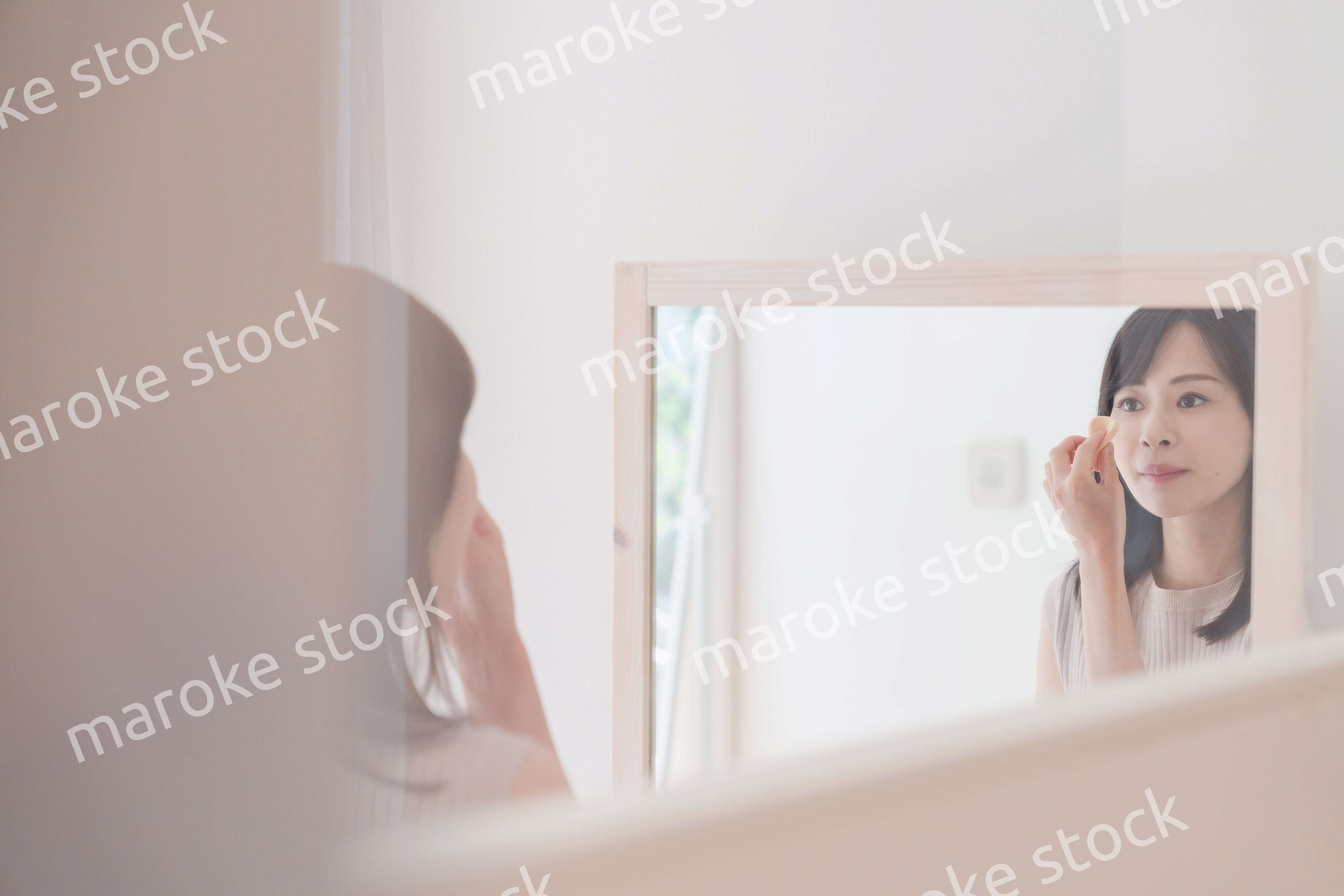 家でメイクをする若い女性