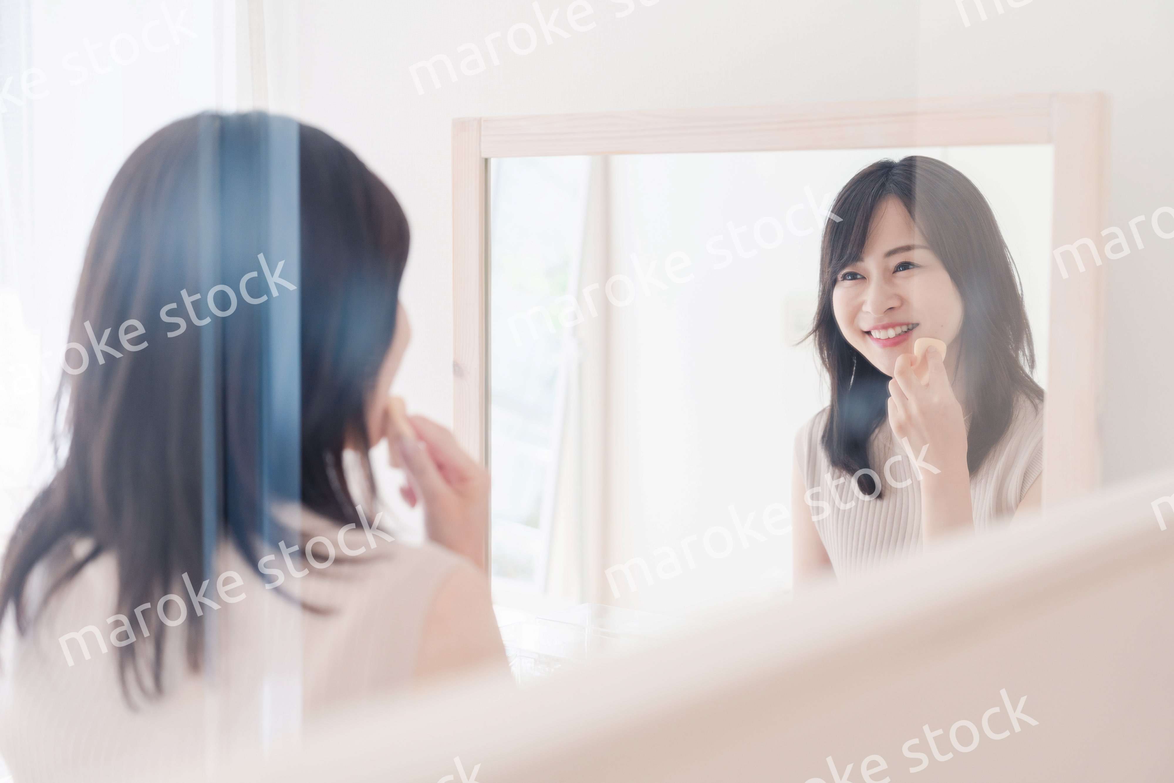 家でメイクをする若い女性