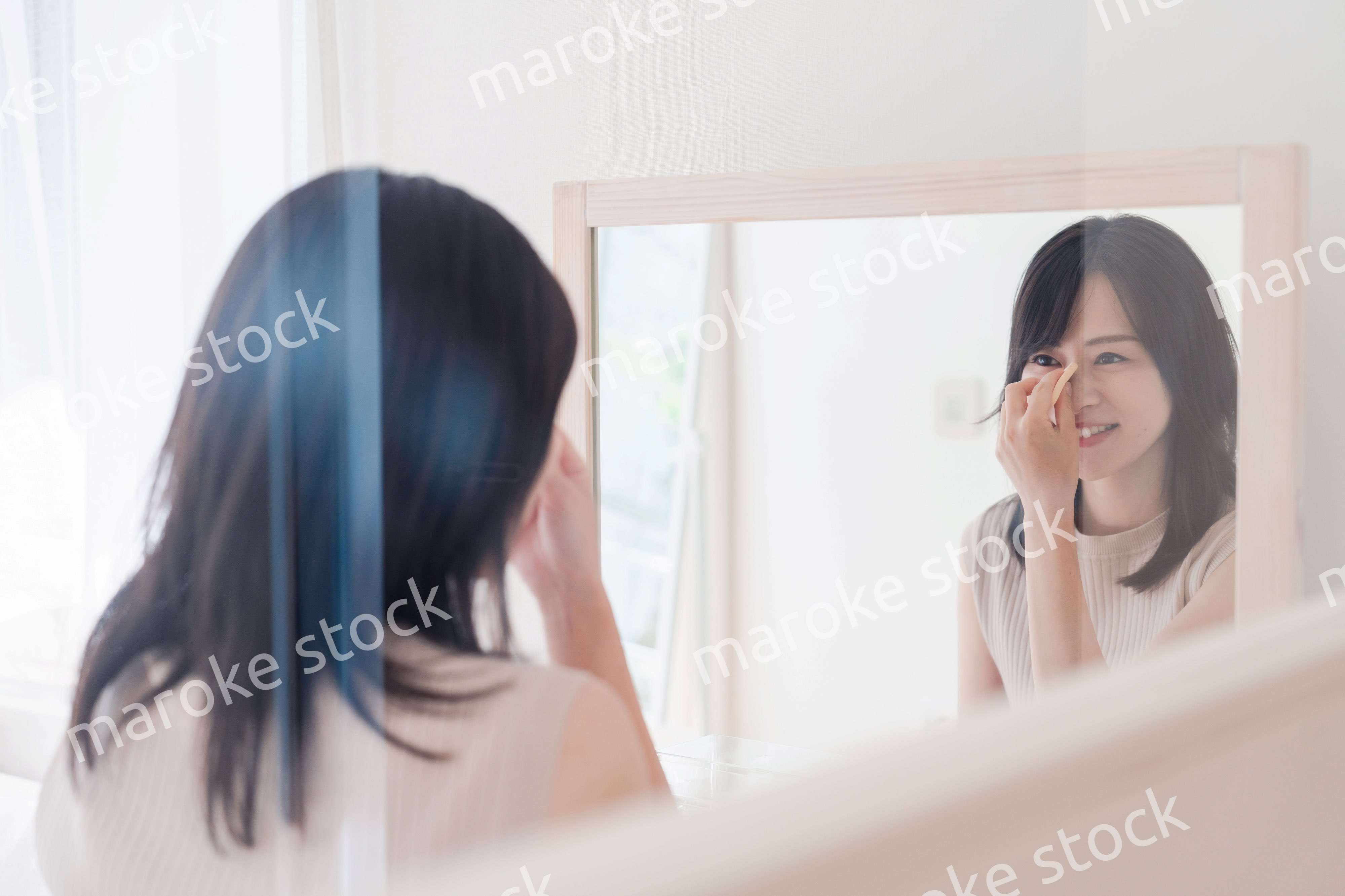 家でメイクをする若い女性