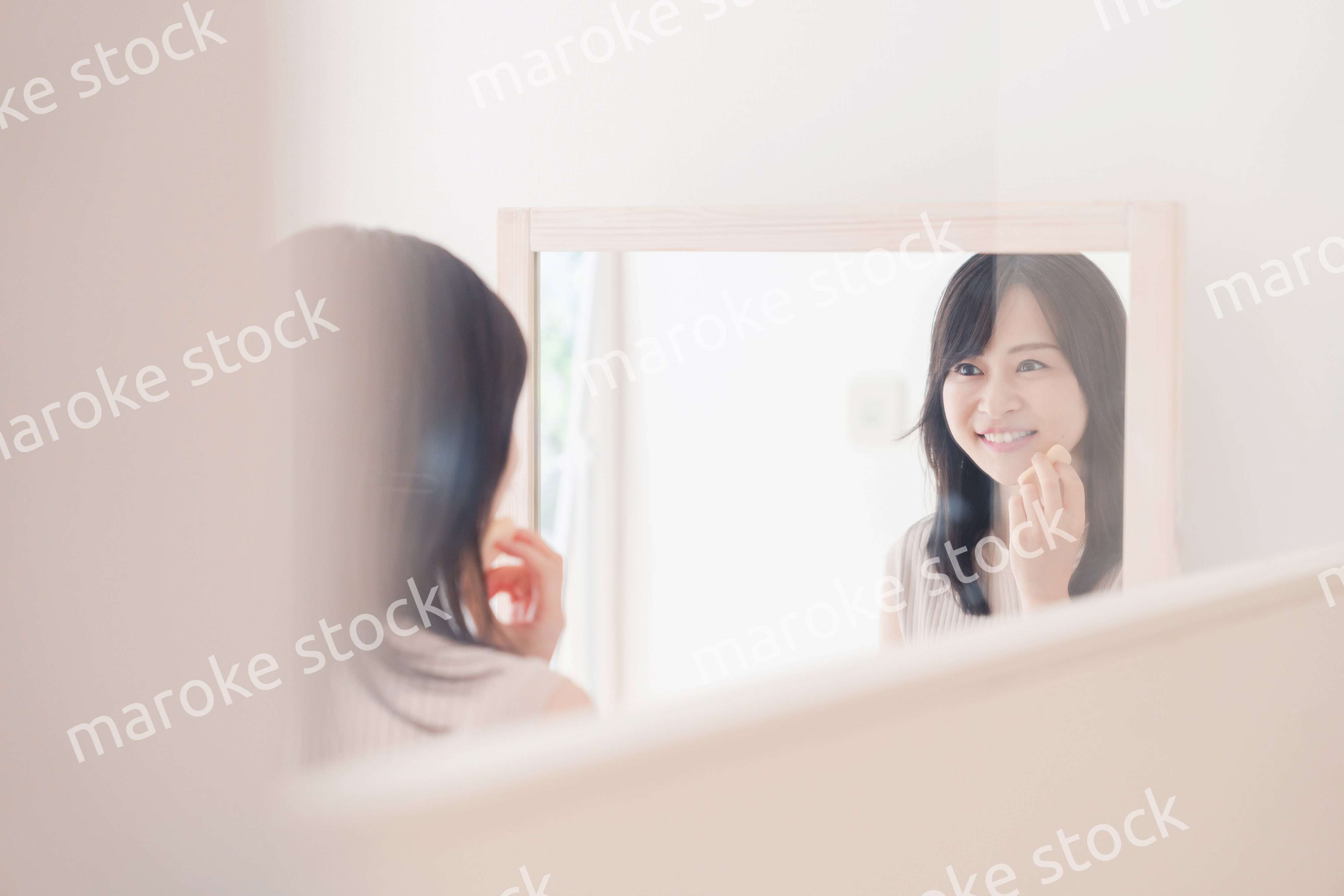 家でメイクをする若い女性