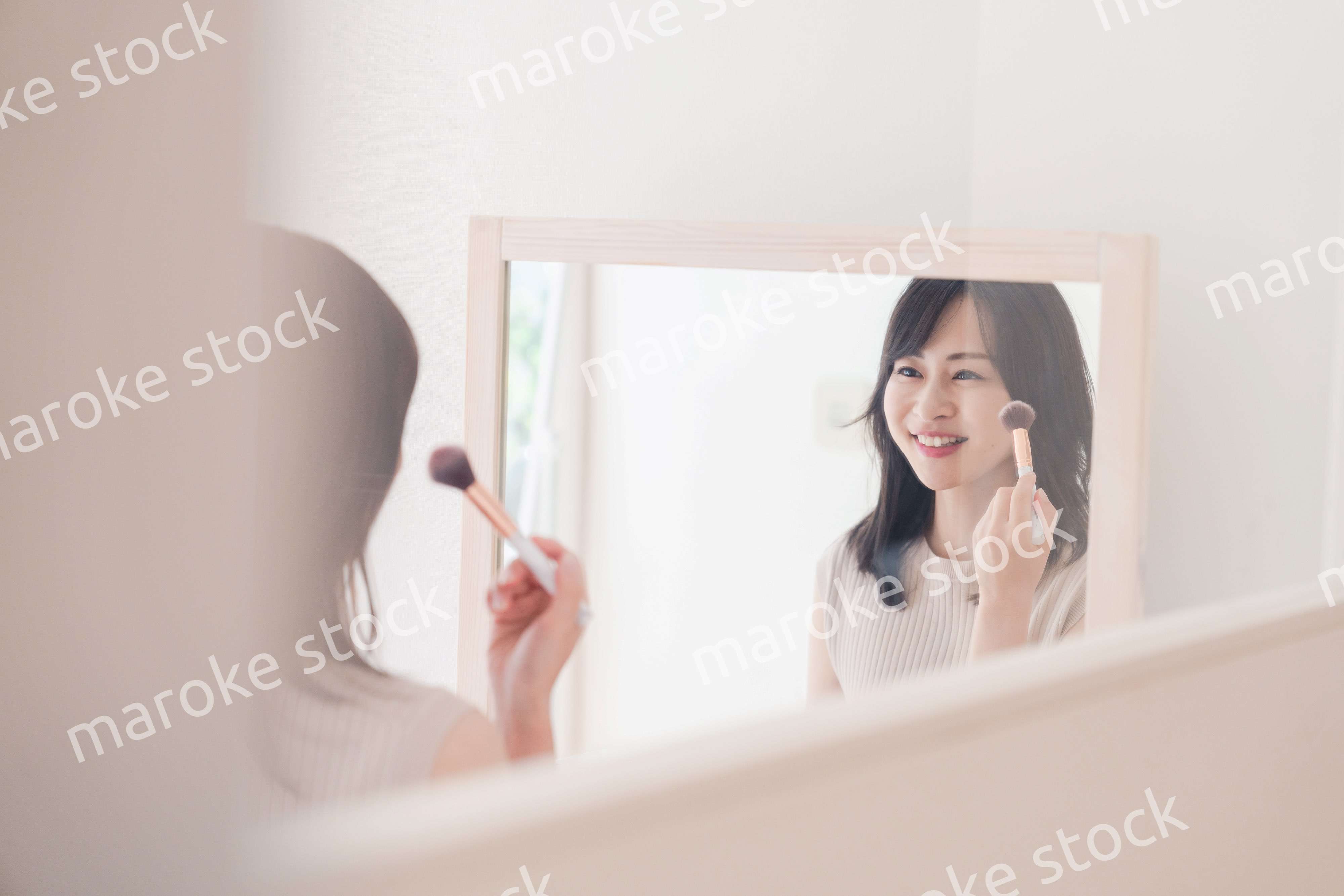 家でメイクをする若い女性