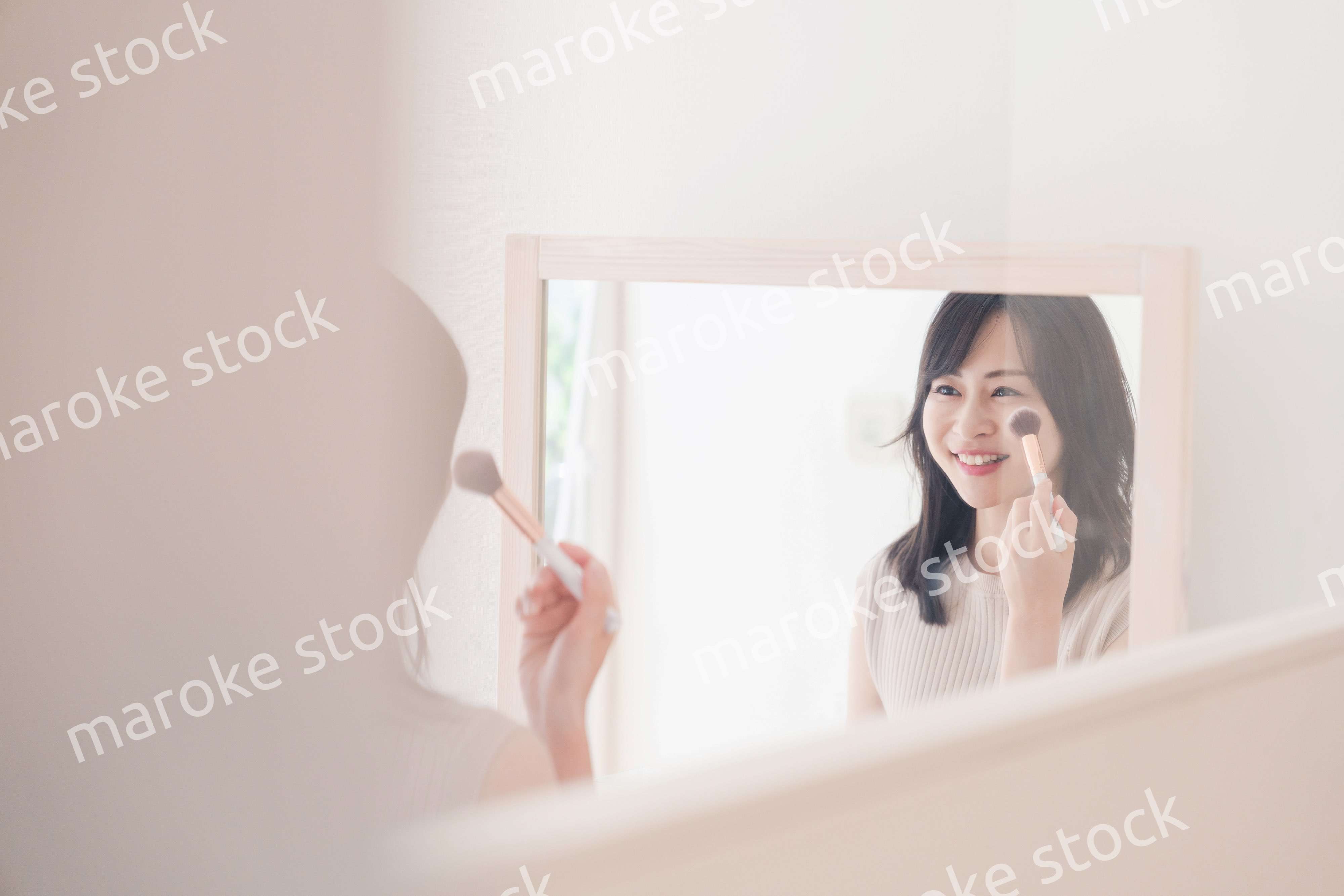 家でメイクをする若い女性