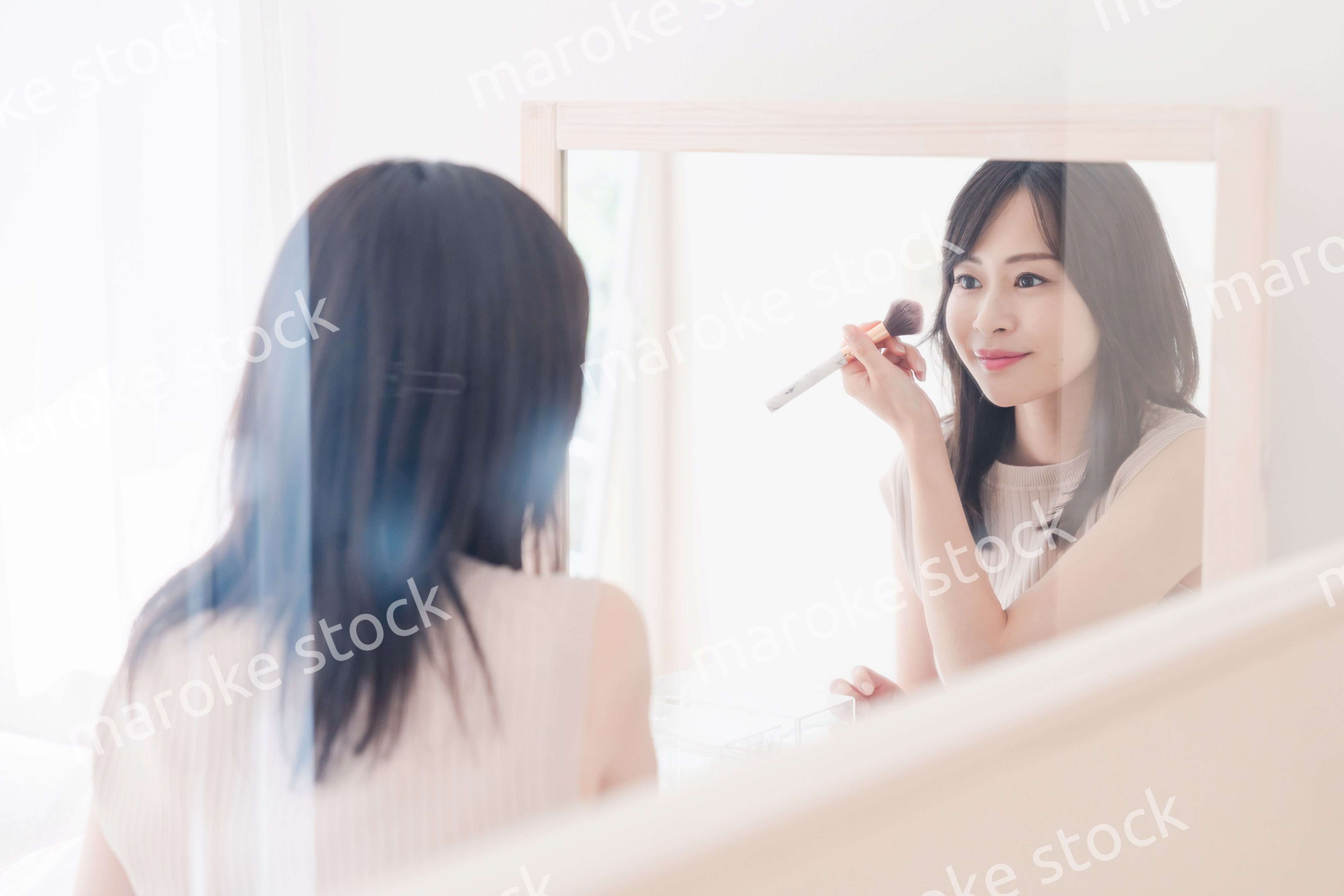 家でメイクをする若い女性