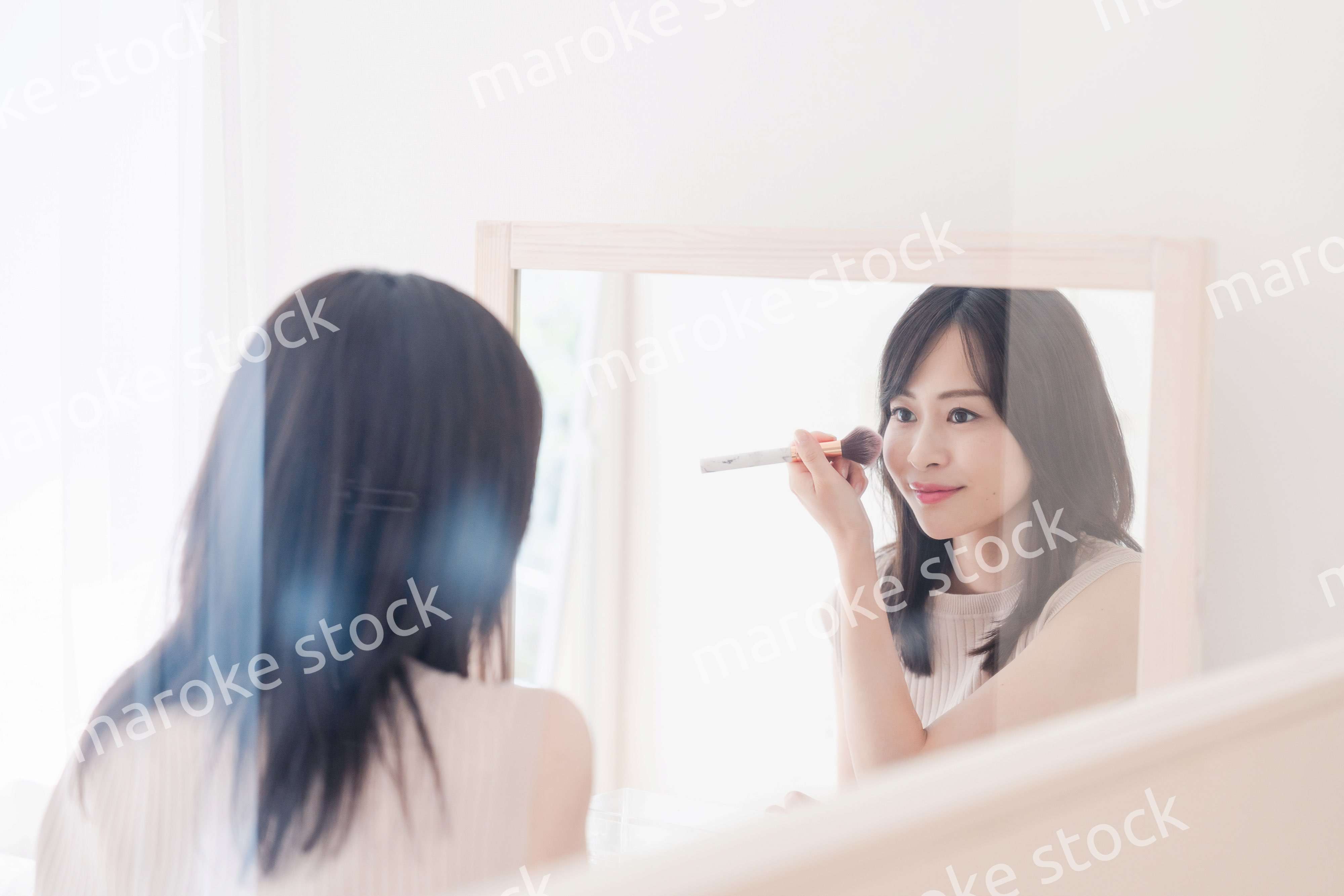 家でメイクをする若い女性