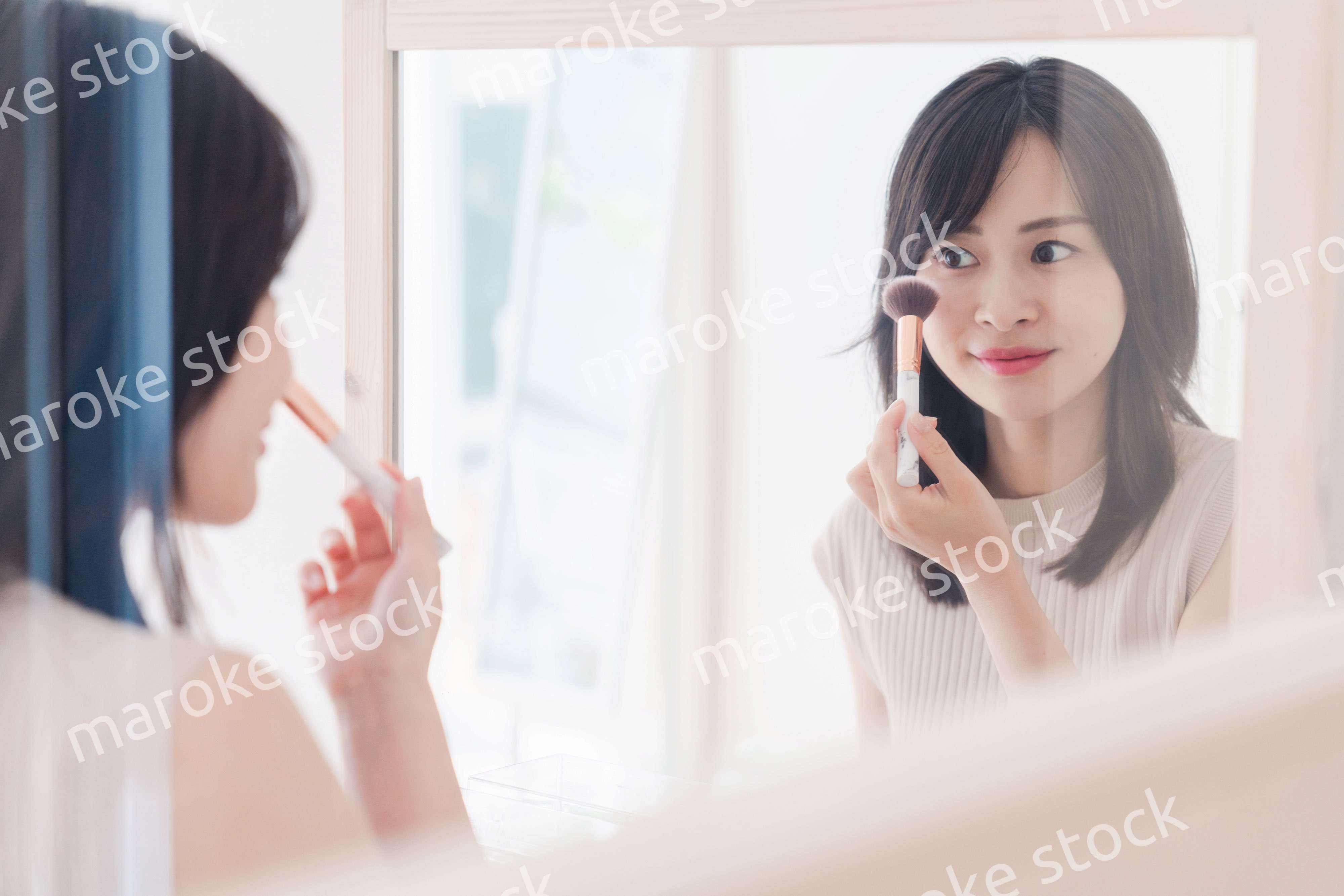 家でメイクをする若い女性