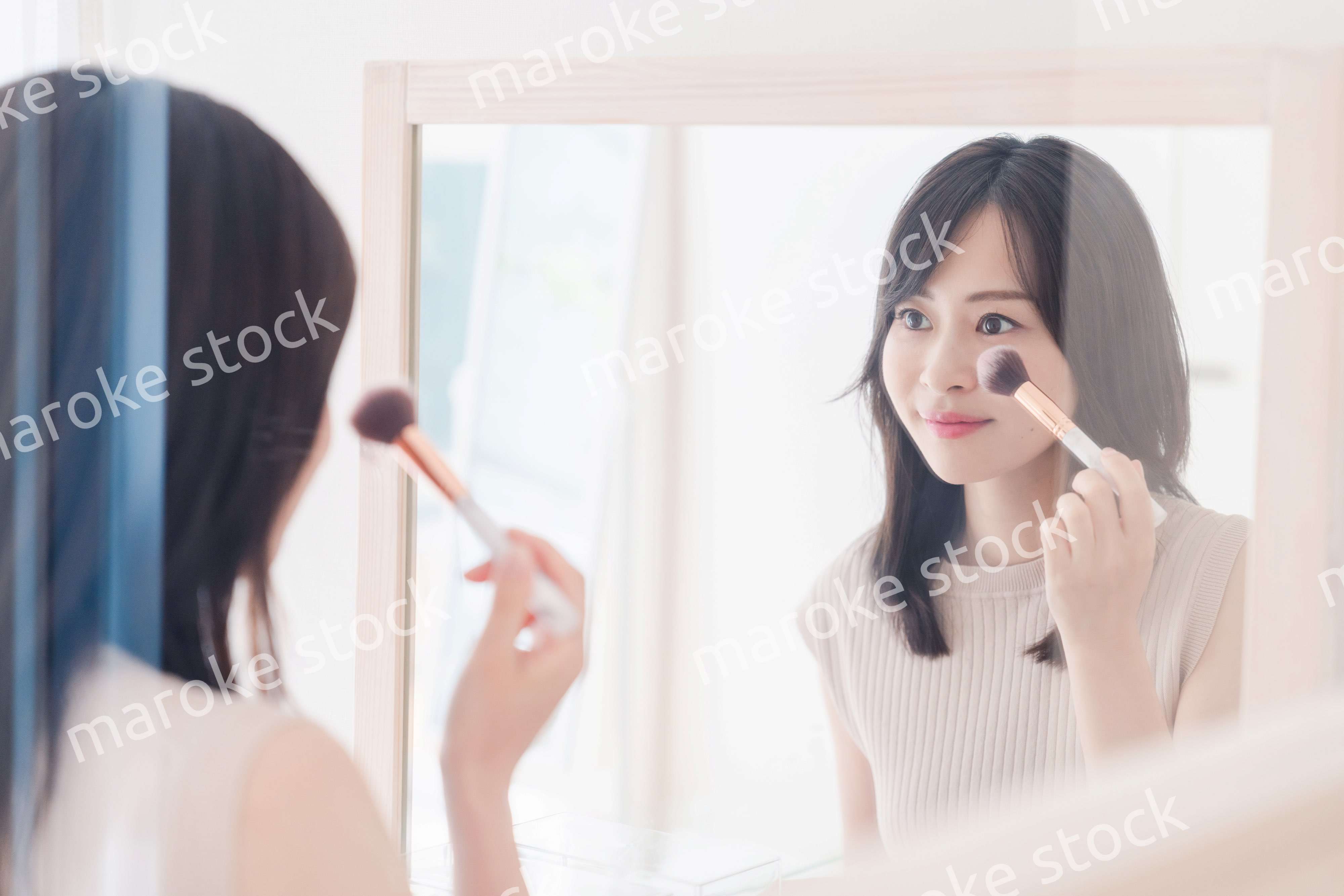 家でメイクをする若い女性