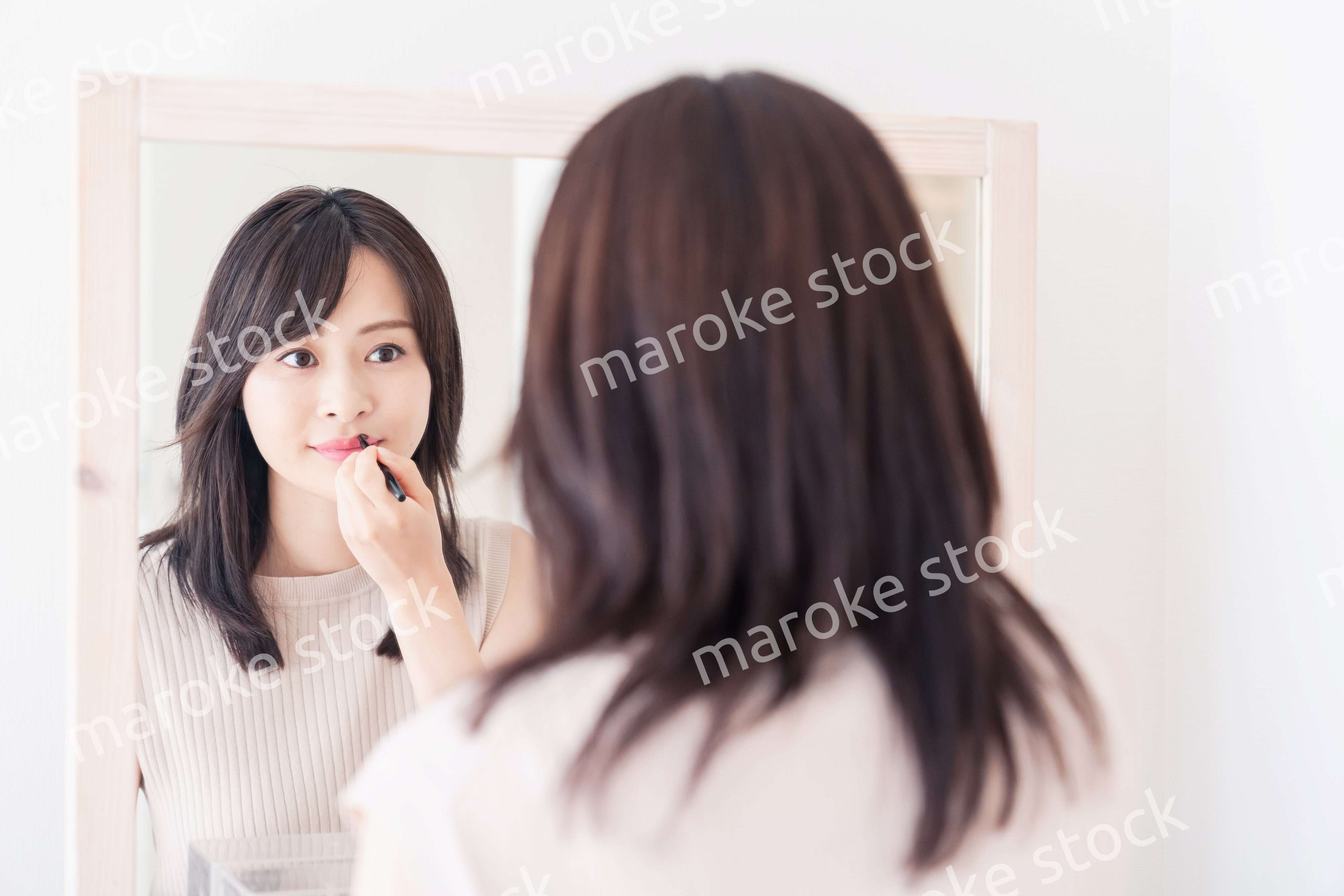 家でメイクをする若い女性