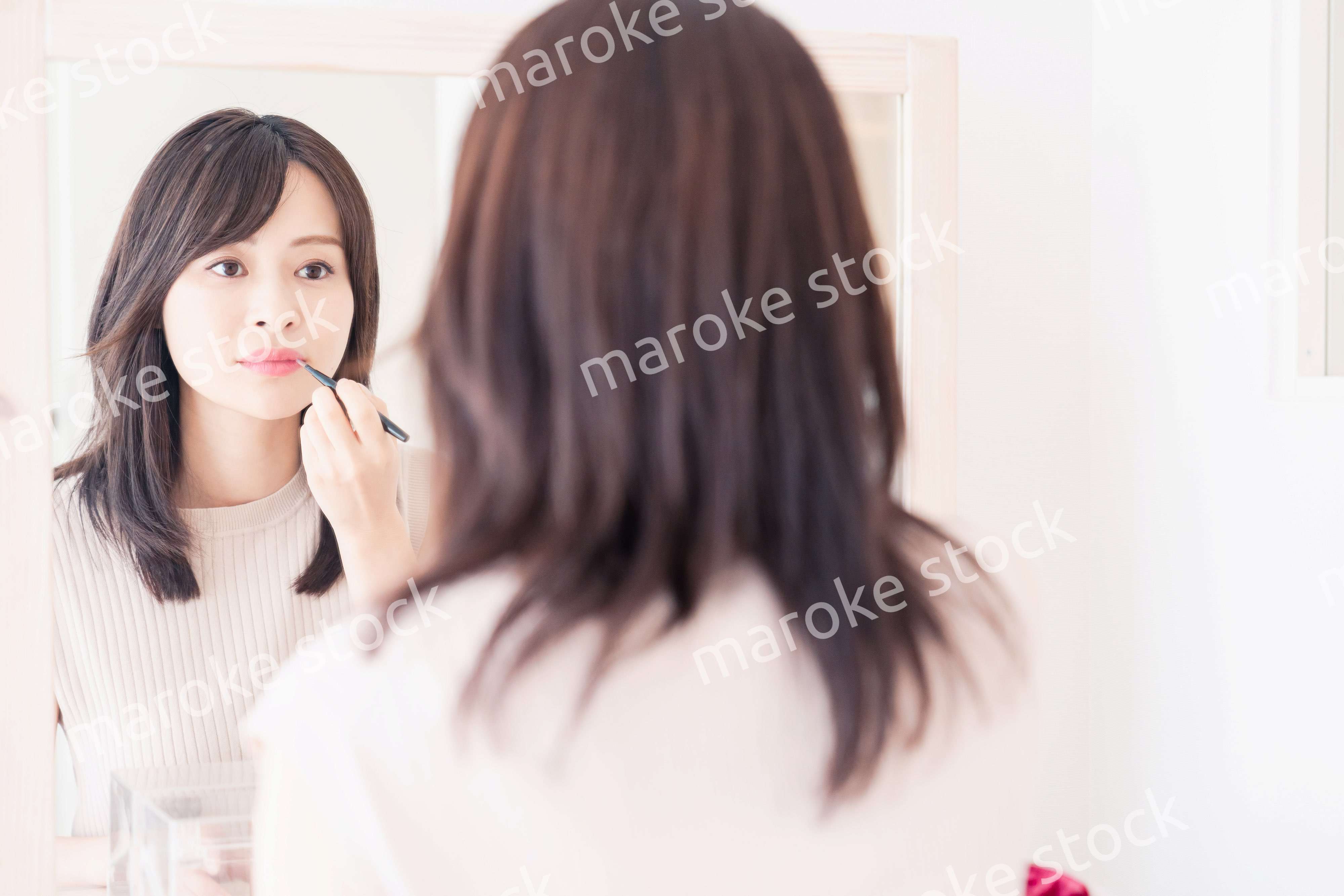 家でメイクをする若い女性