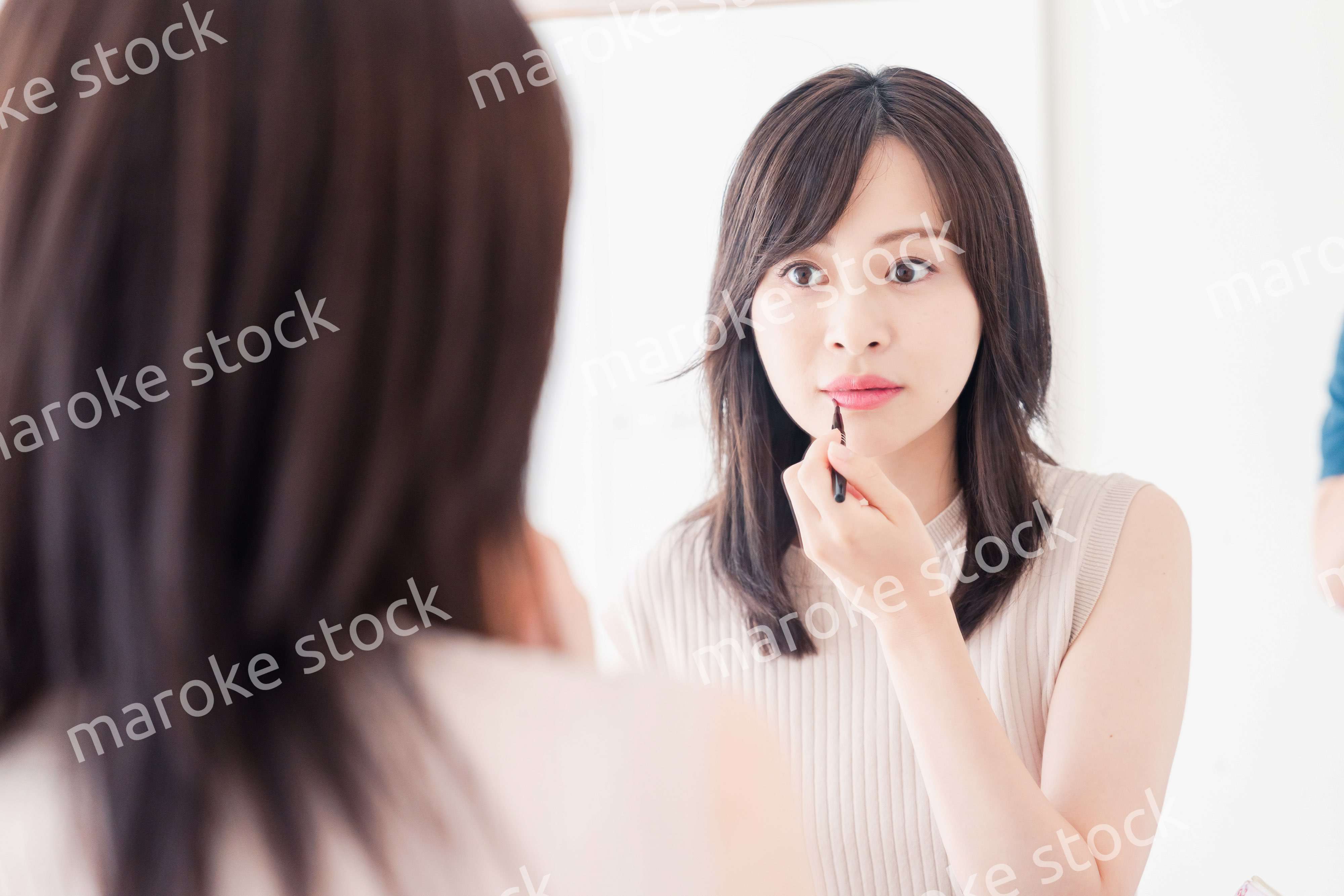 家でメイクをする若い女性