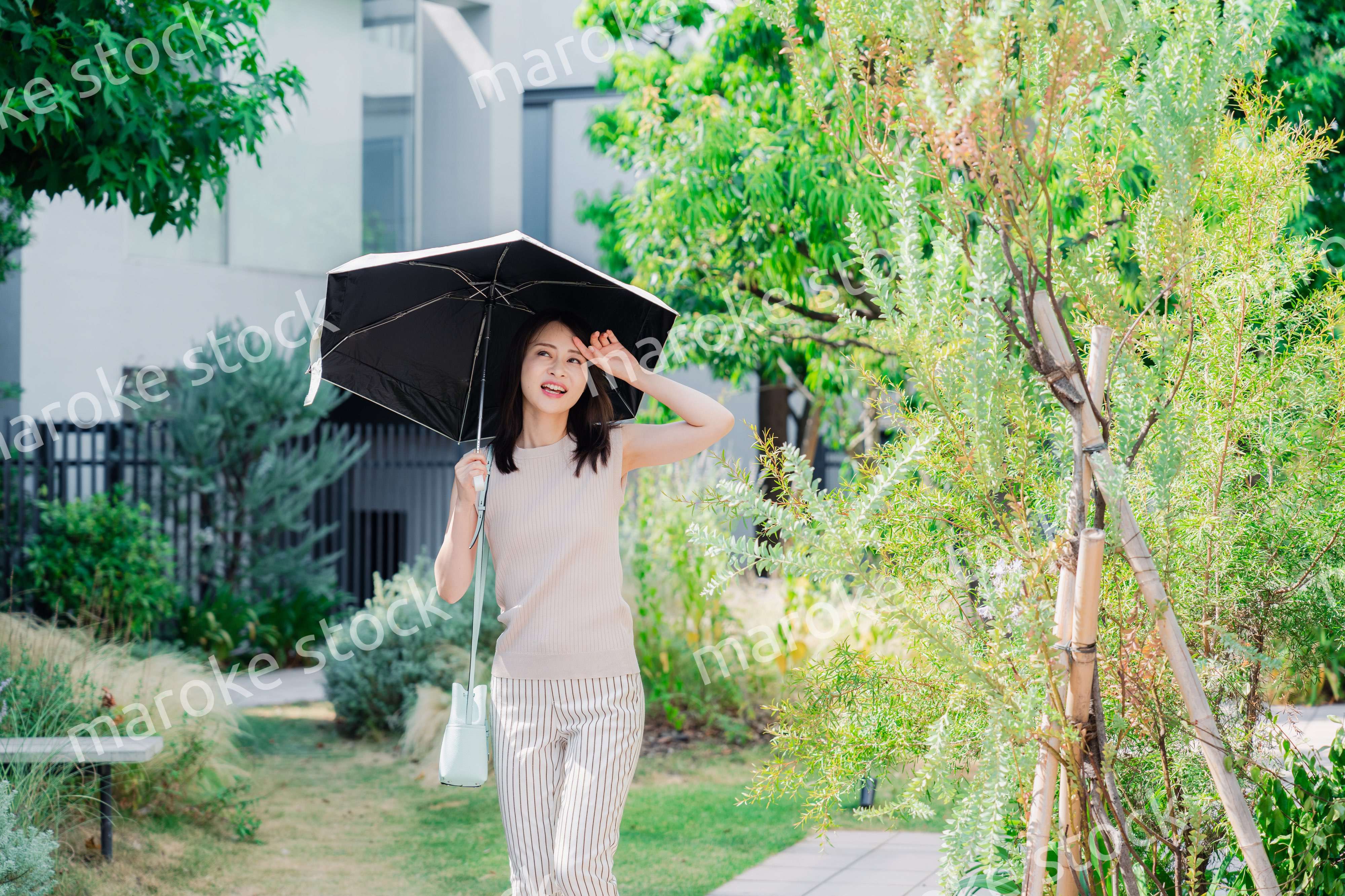 日傘を差して外を歩く若い女性