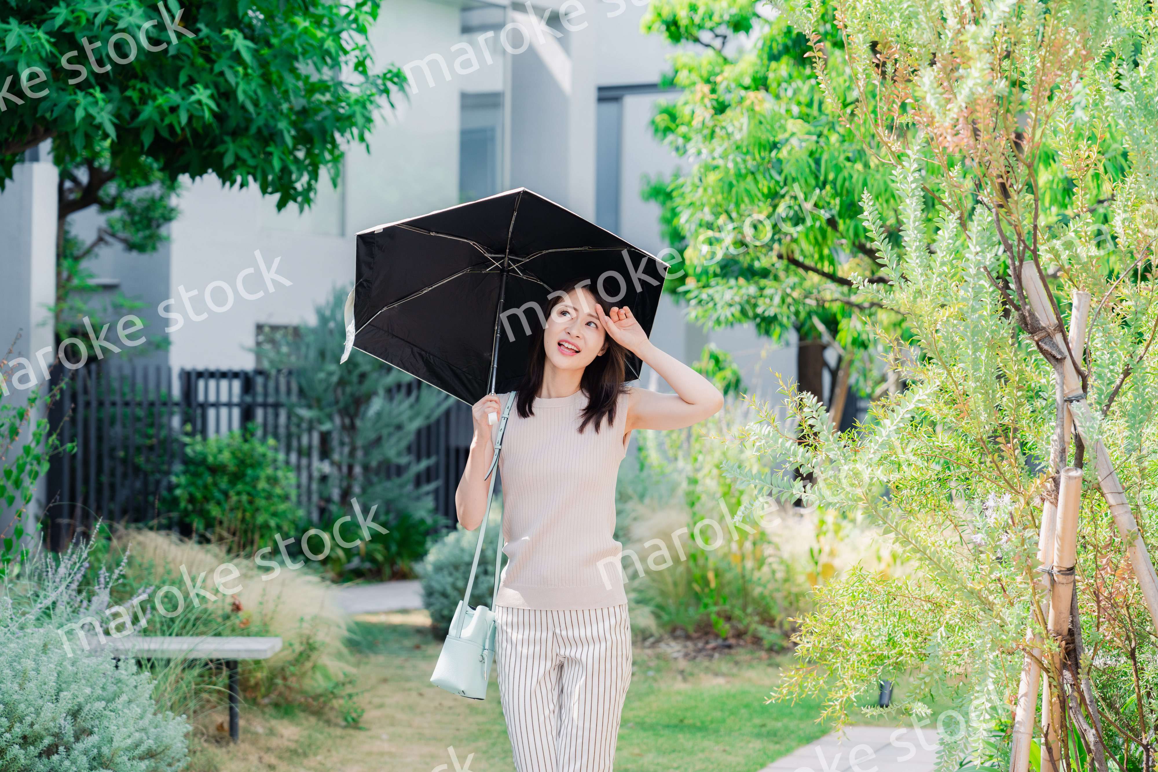 日傘を差して外を歩く若い女性