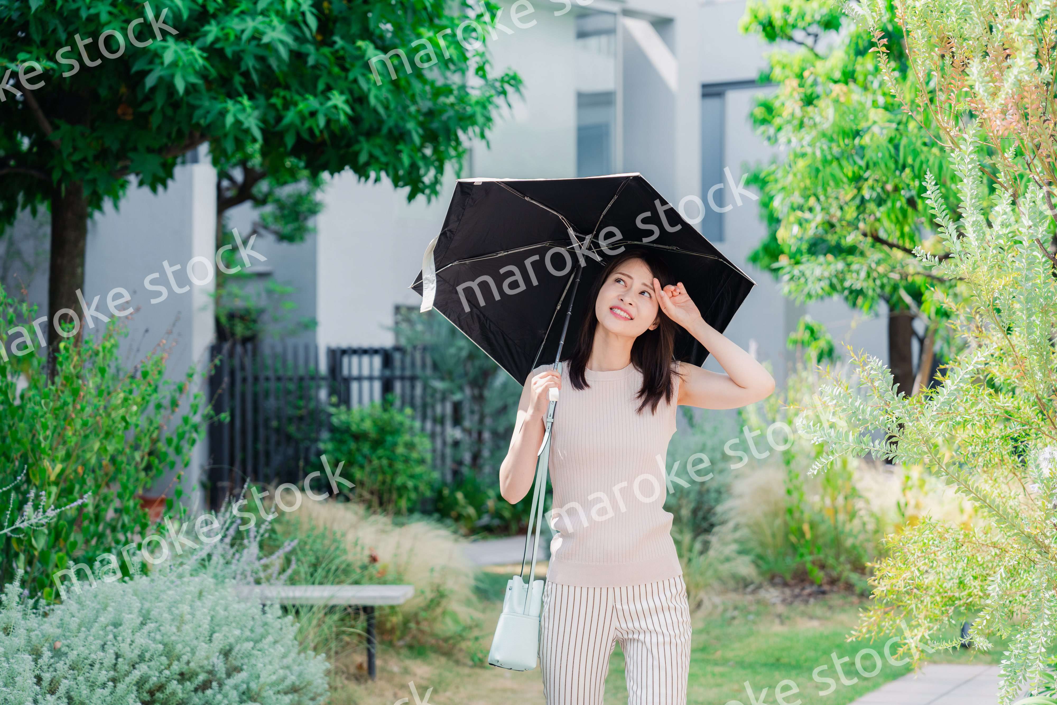 日傘を差して外を歩く若い女性