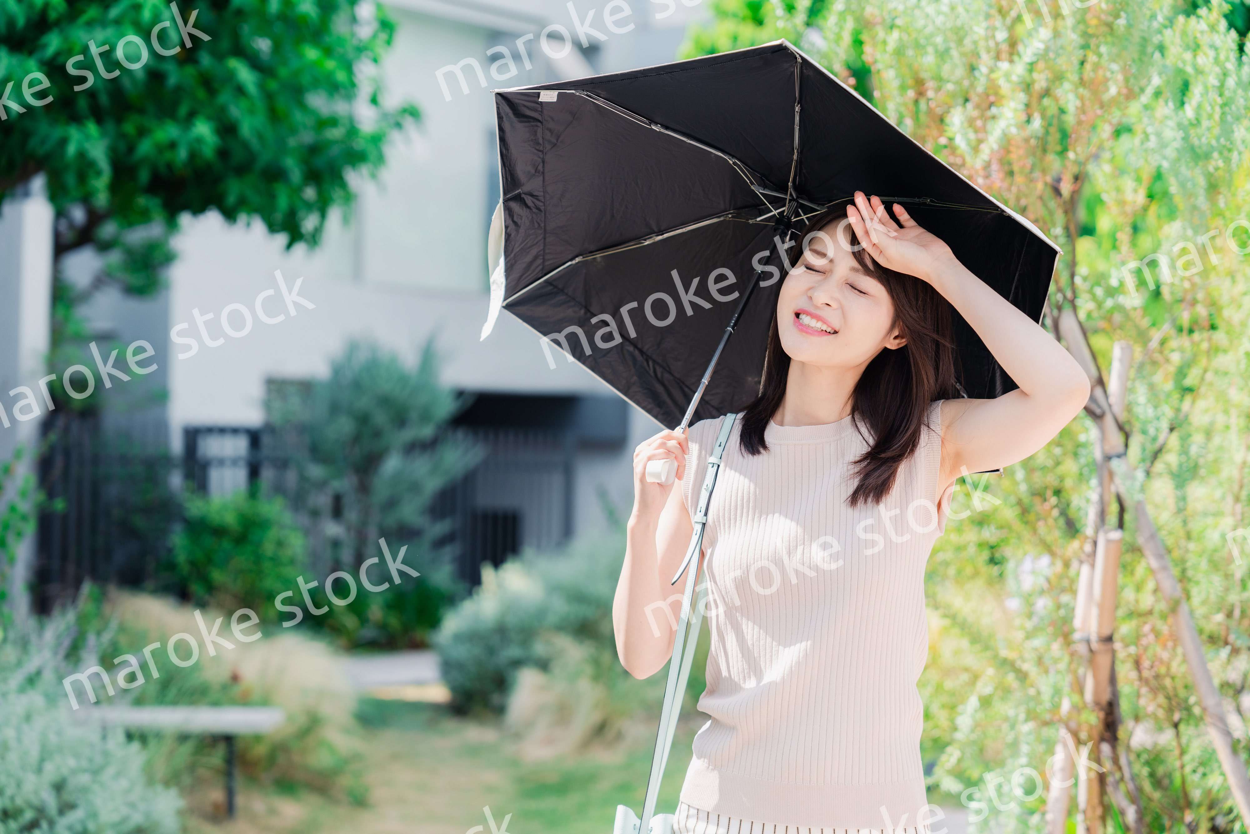 日傘を差して外を歩く若い女性