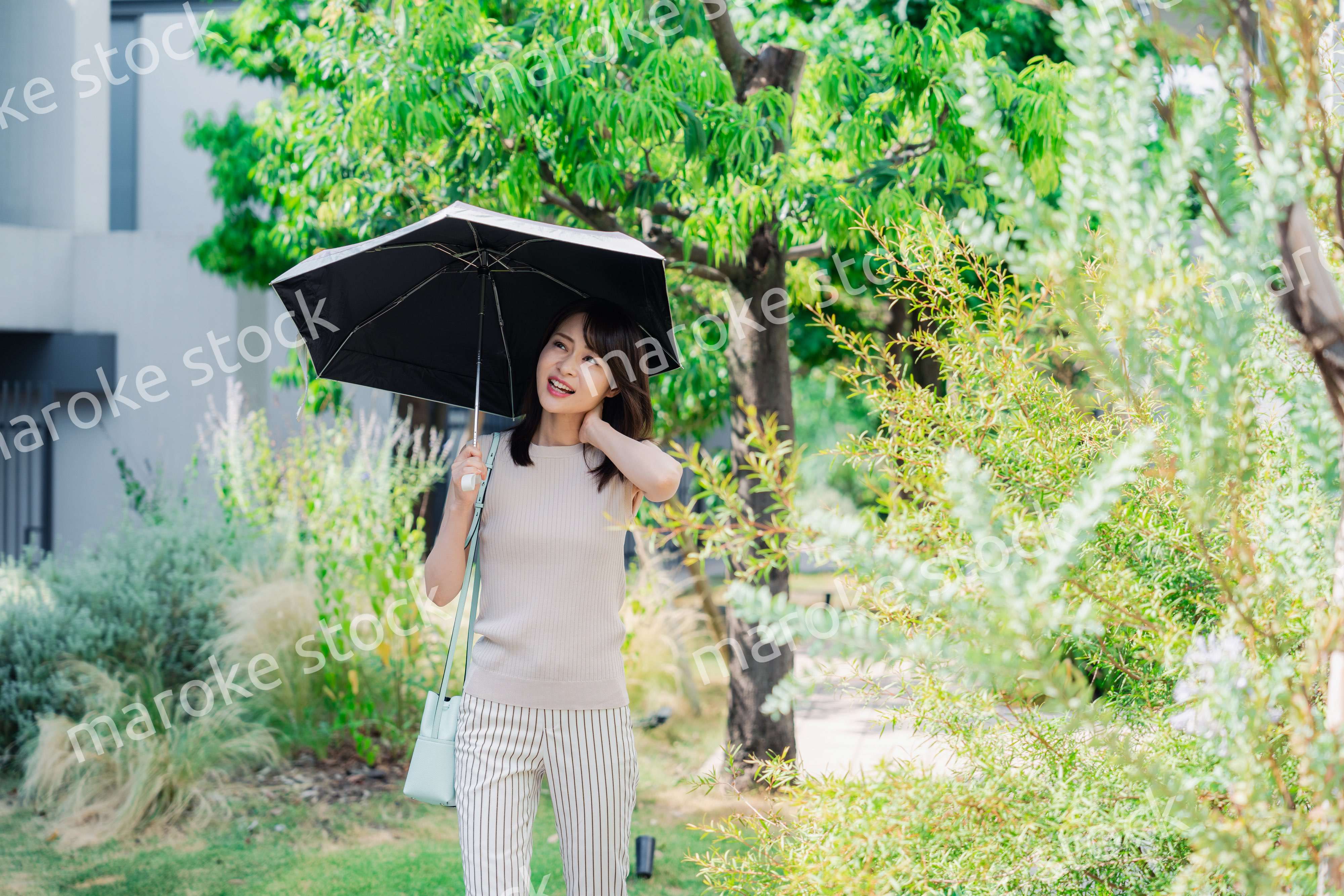 日傘を差して外を歩く若い女性