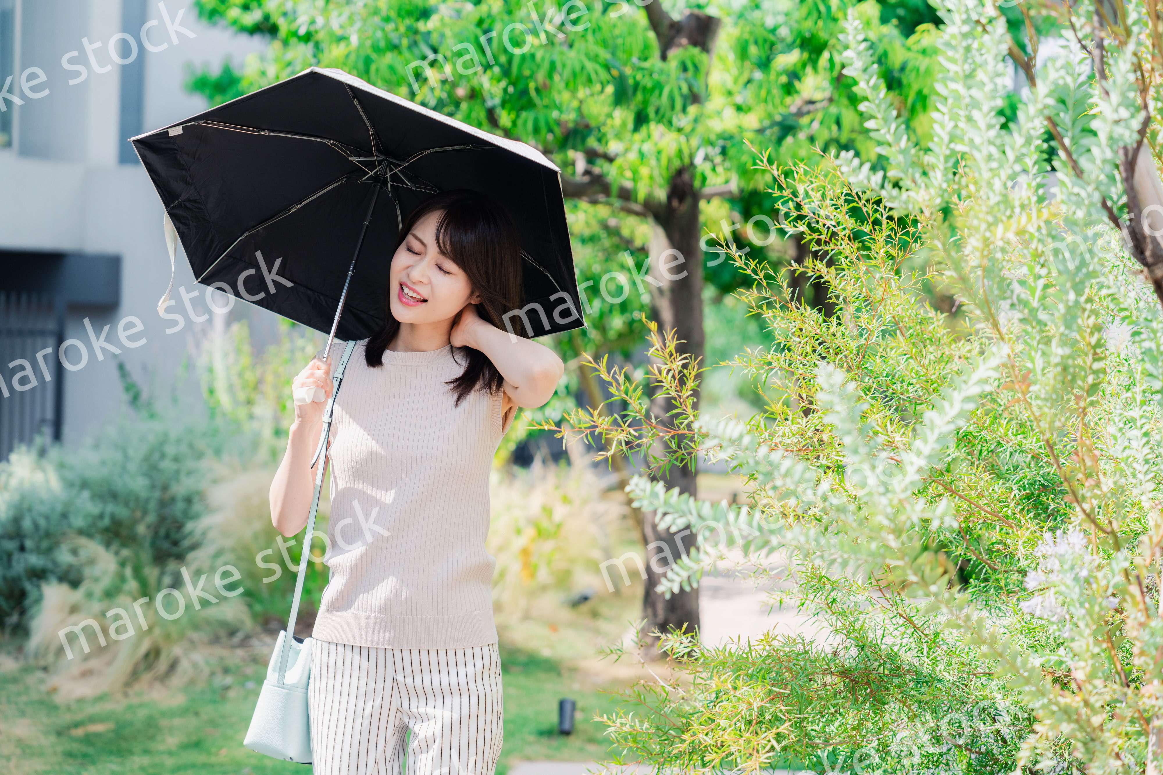 日傘を差して外を歩く若い女性