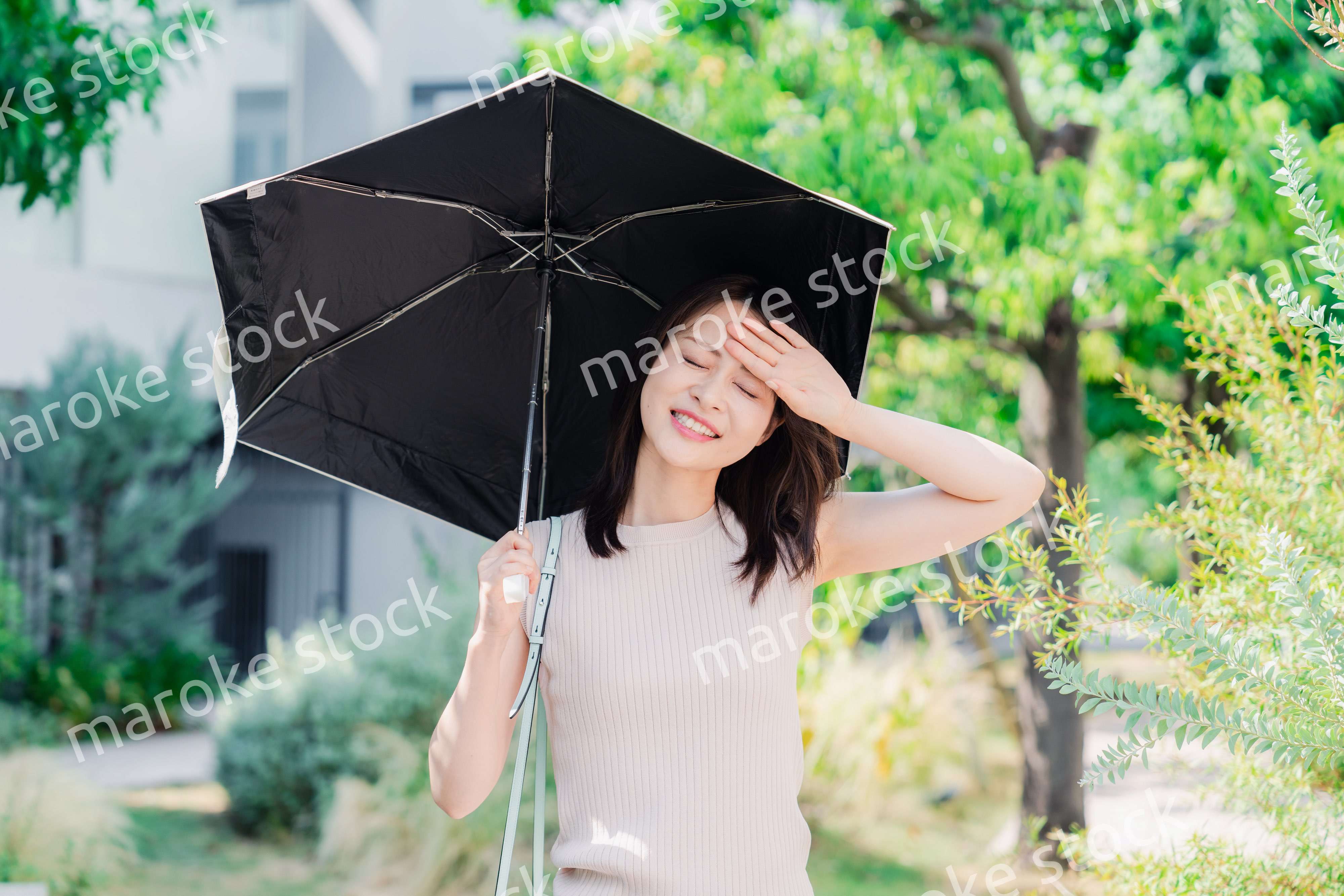 日傘を差して外を歩く若い女性