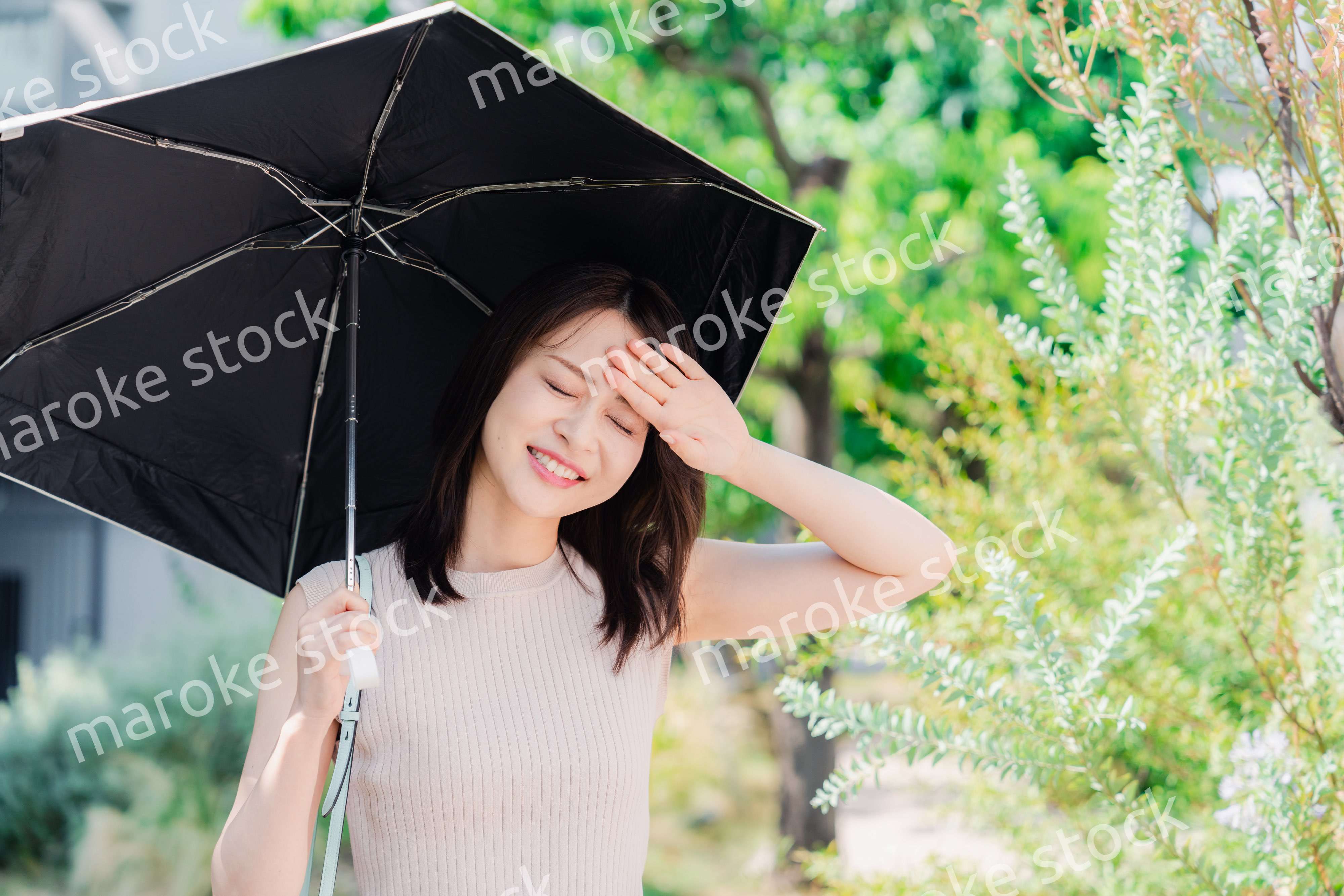 日傘を差して外を歩く若い女性